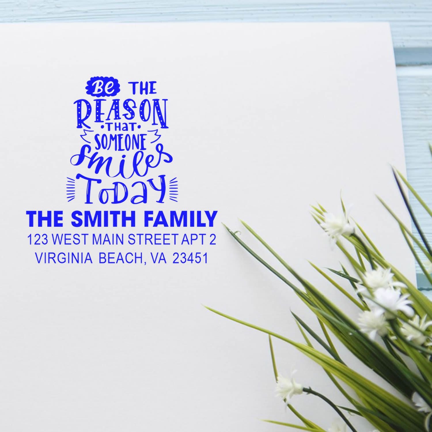 Custom personalized blue ink rubber stamp with inspirational quote and return address for The Smith Family on a white envelope.