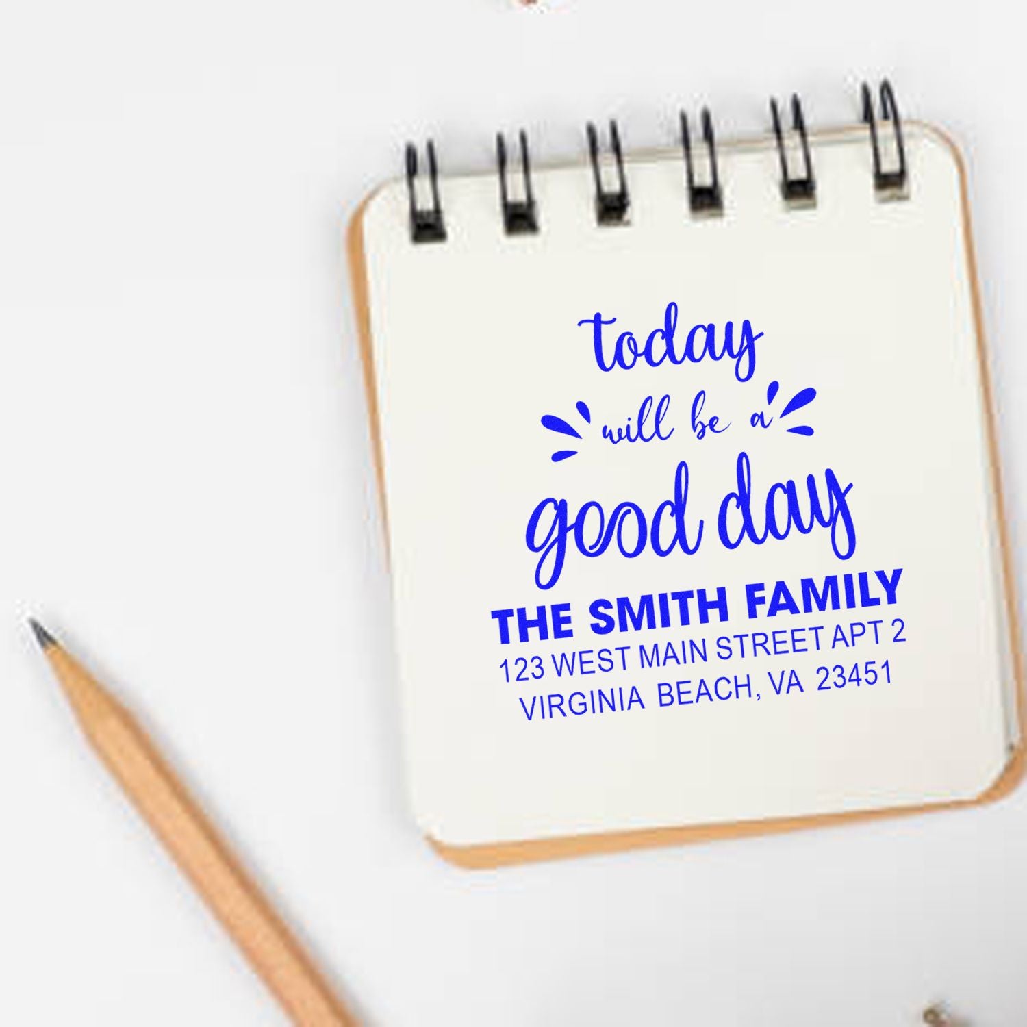Custom rubber stamp on notebook reading today will be a good day with The Smith Family address in blue ink.