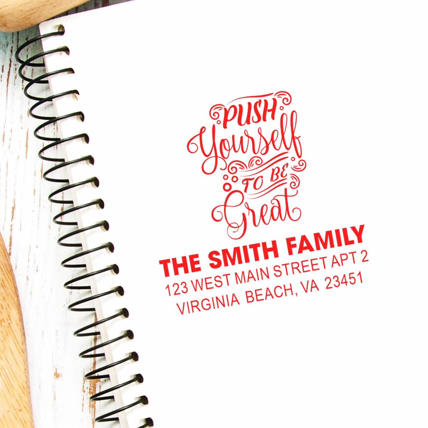 Custom address rubber stamp with inspirational quote, shown stamped in a notebook for The Smith Family.