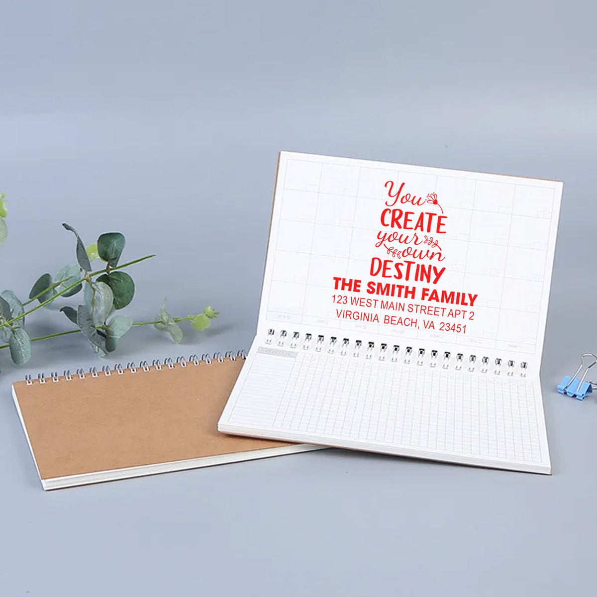 Custom rubber stamp sample on notebook showing a personalized family address design for stationery and branding.