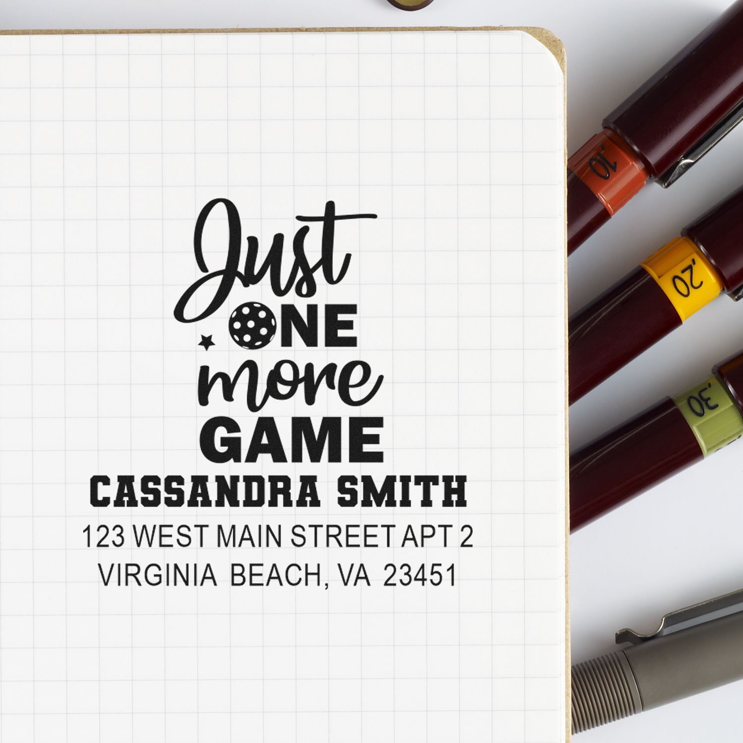 Custom rubber address stamp with Just One More Game quote, name, and return address for personalized gamer stationery.