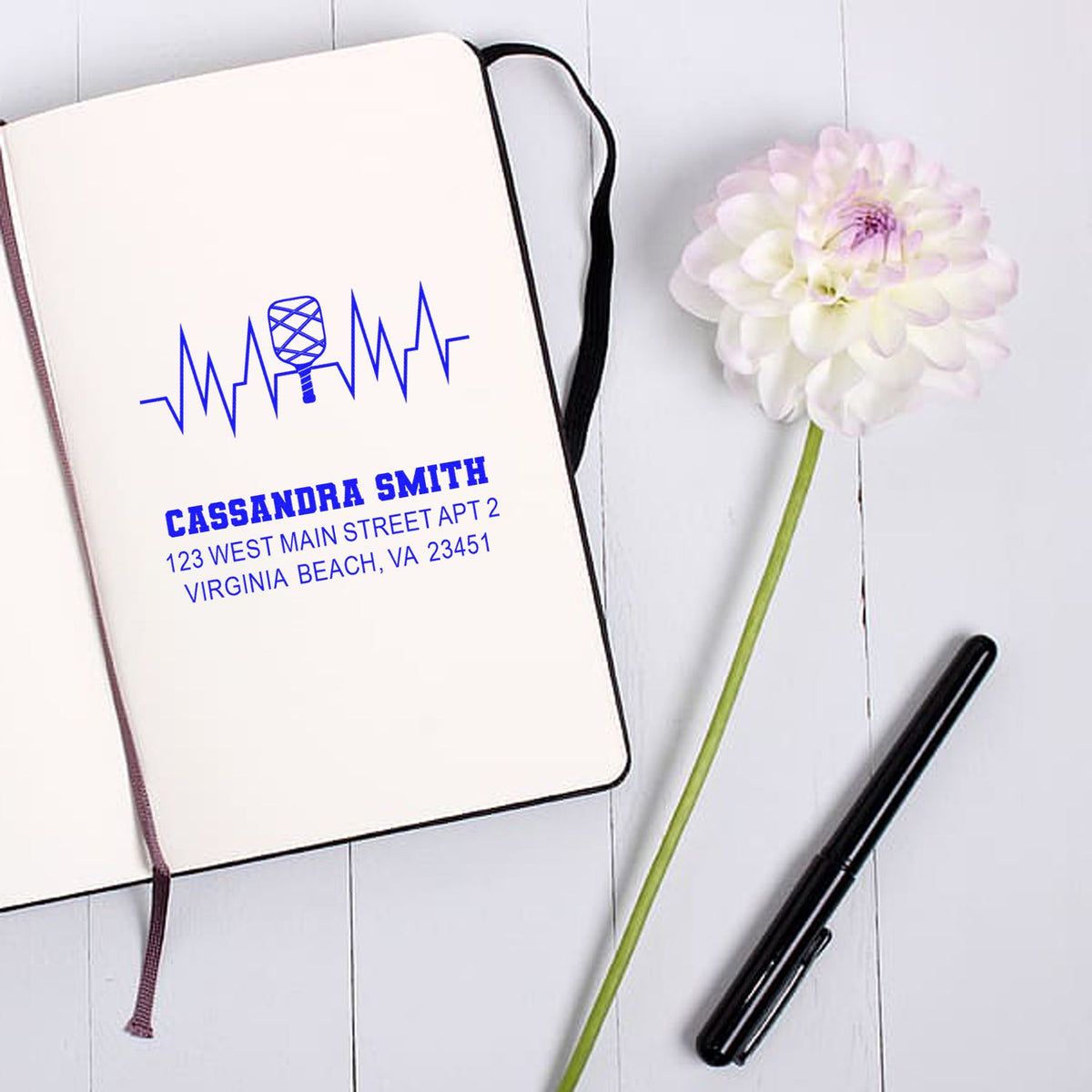 Custom return address rubber stamp with name, address, and heartbeat microphone logo for personalized stationery.