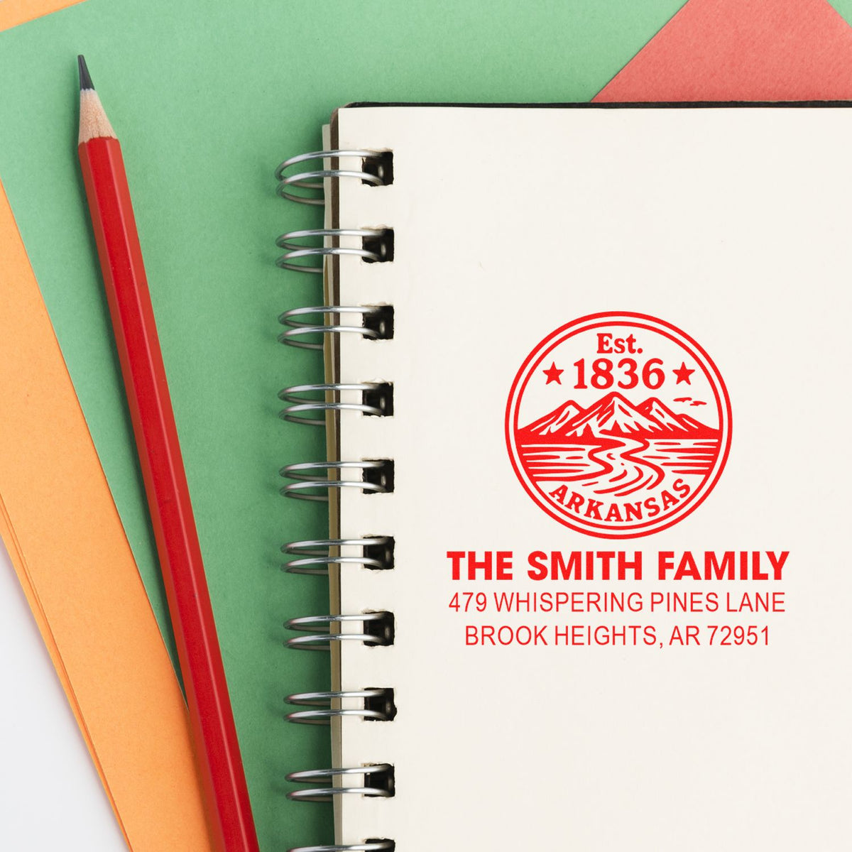Custom family return address rubber stamp on notebook, featuring Arkansas design and personalized home address imprint.