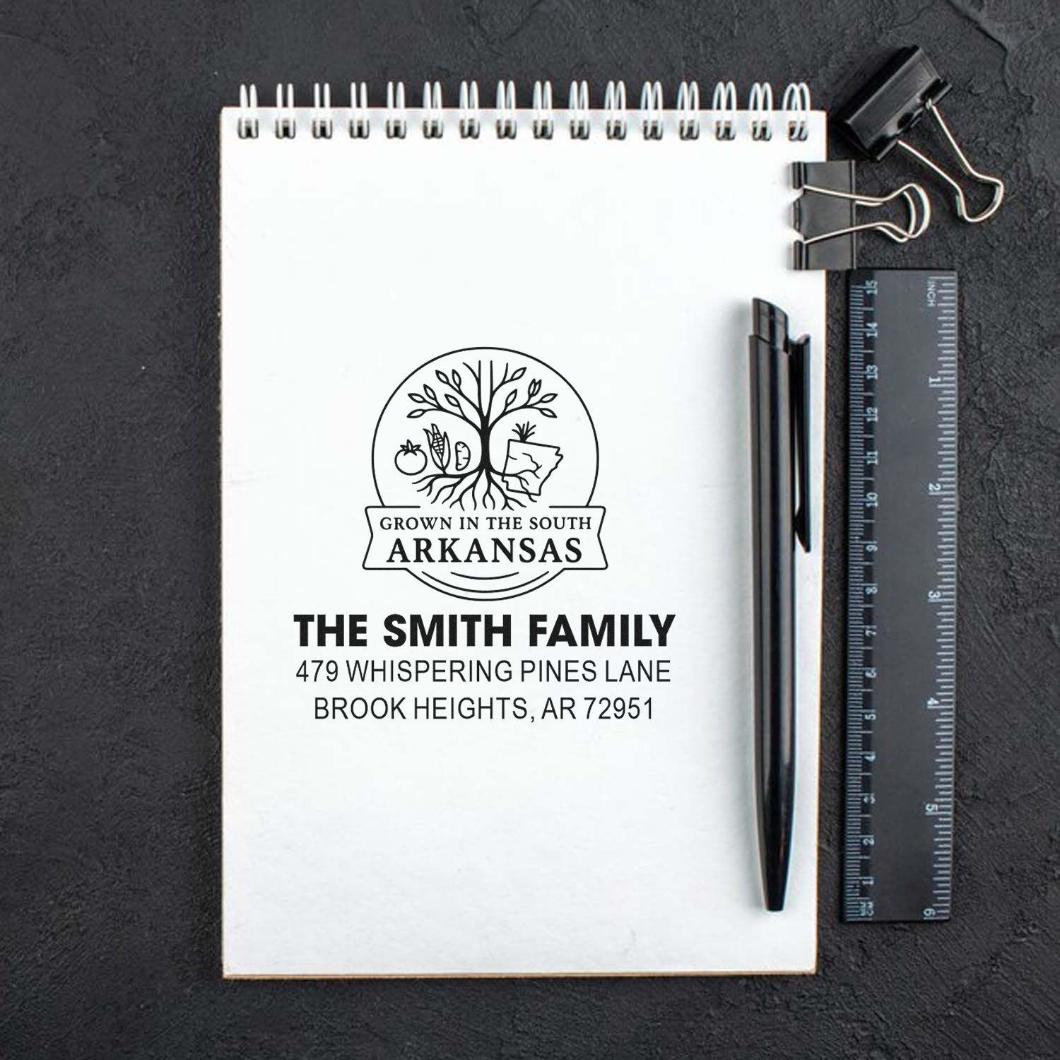 Custom return address rubber stamp mockup for a family home, featuring Arkansas address branding on a notebook