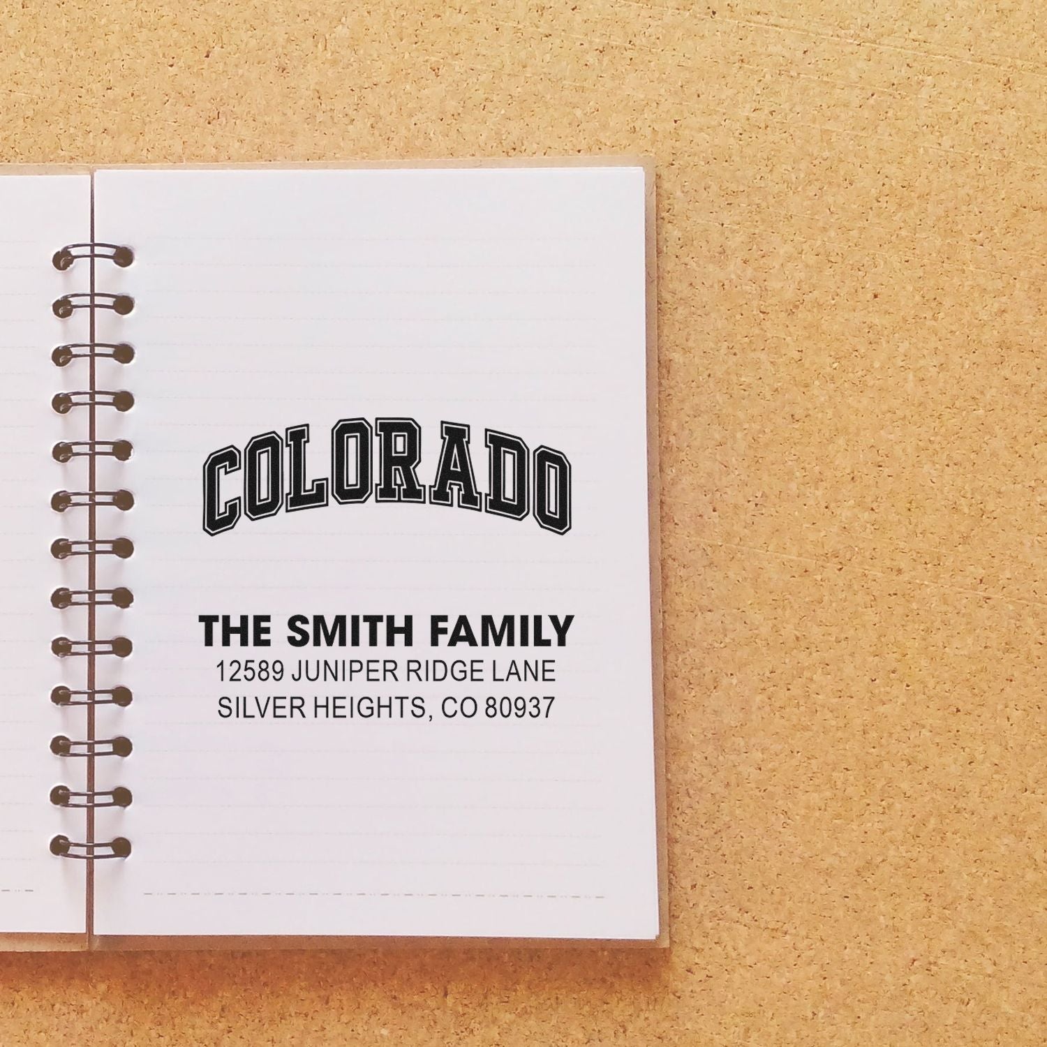 Personalized Colorado family address rubber stamp on notebook, featuring The Smith Family and Silver Heights, CO address.