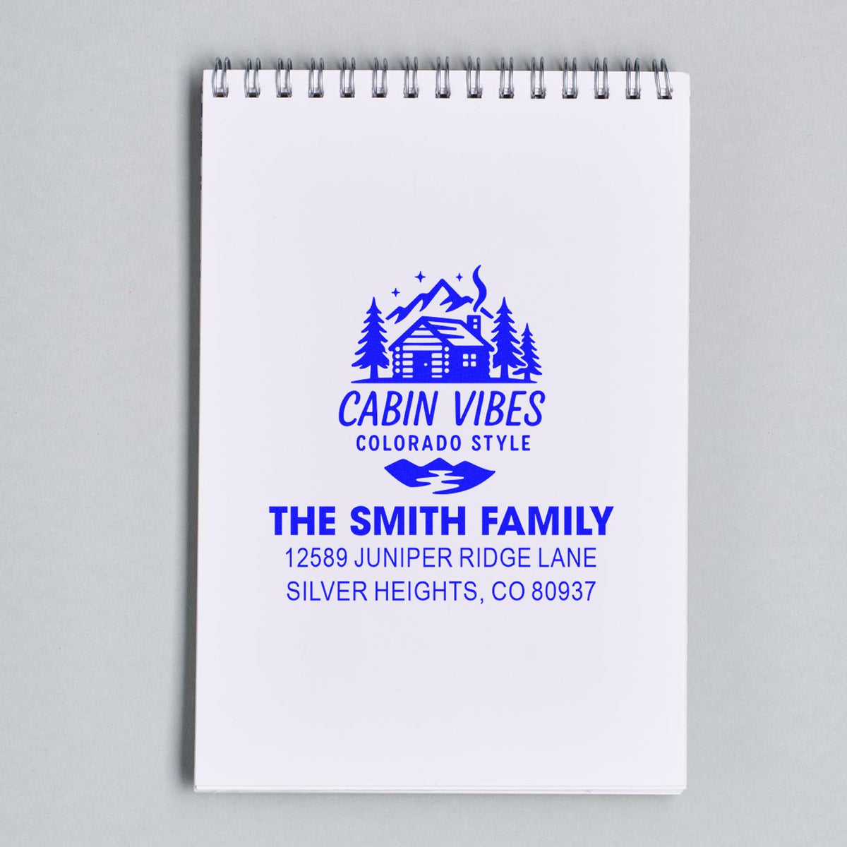 Custom rubber stamp impression with cabin design, The Smith Family name, and Colorado address for personalized stationery.