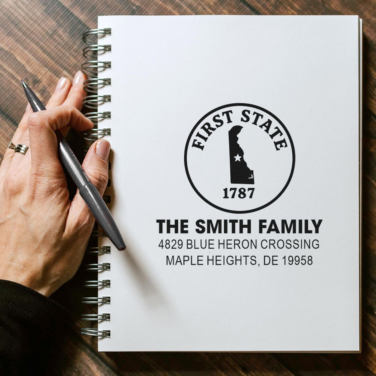 Custom First State rubber stamp with family name and return address for personalized stationery and envelope addressing.