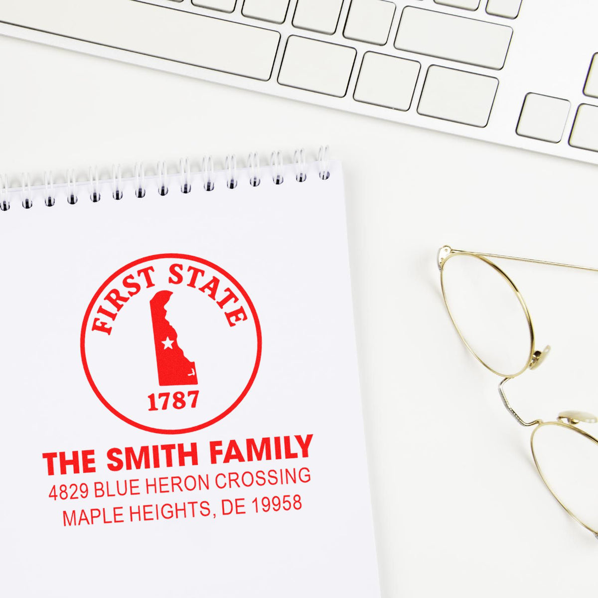 Custom First State family address rubber stamp on notepad, featuring a Delaware home design and personalized return address.