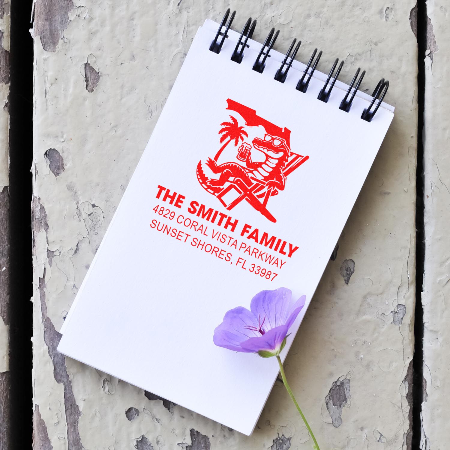 Custom family address rubber stamp with alligator logo on notebook