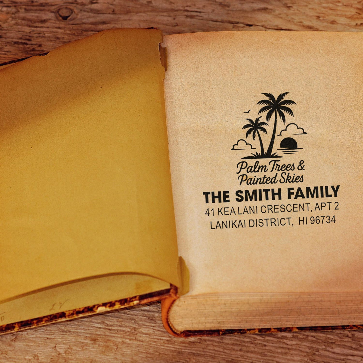 Custom address rubber stamp with palm tree logo for The Smith Family, shown stamped on a book page.
