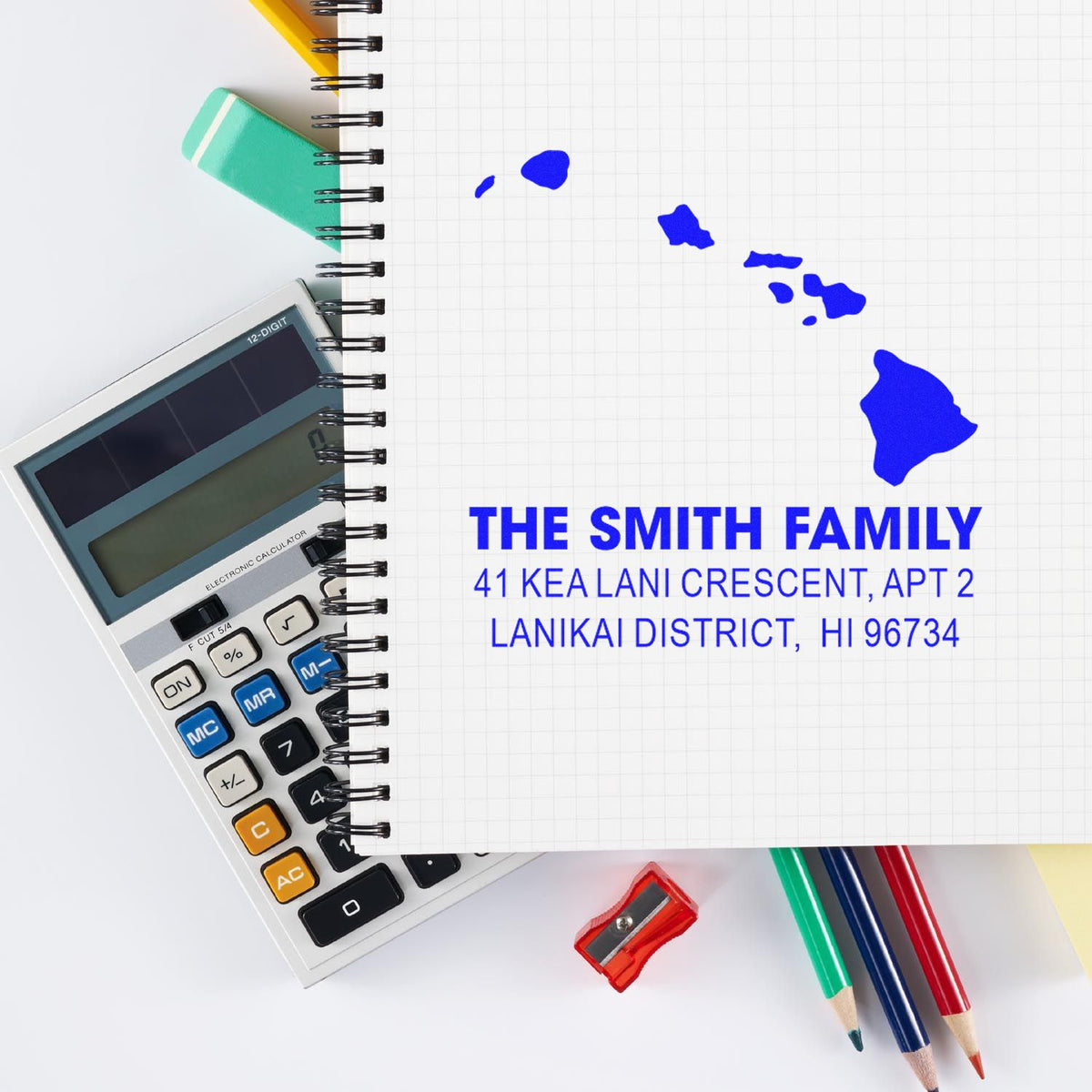 Custom address rubber stamp impression for The Smith Family with Hawaii map on notebook, shown with stationery and calculator.