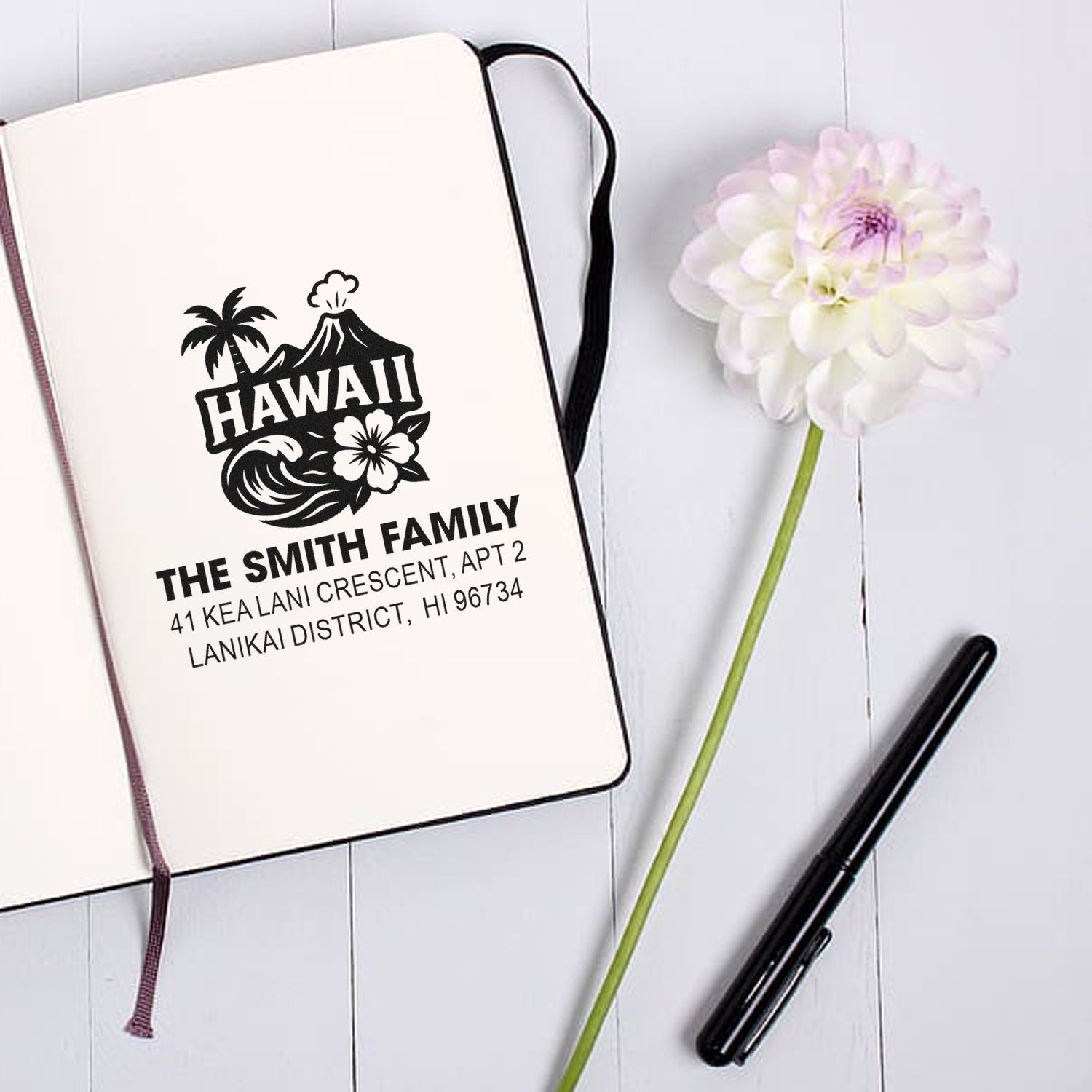 Personalized Hawaii family address rubber stamp with tropical design and return mailing details on a notebook page.