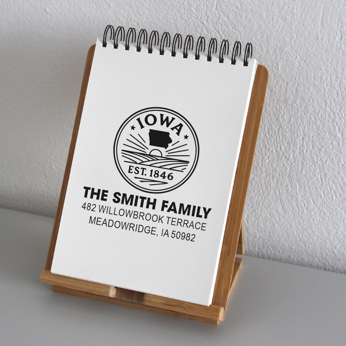 Custom return address rubber stamp with Iowa seal, The Smith Family name, and address printed on a notepad.