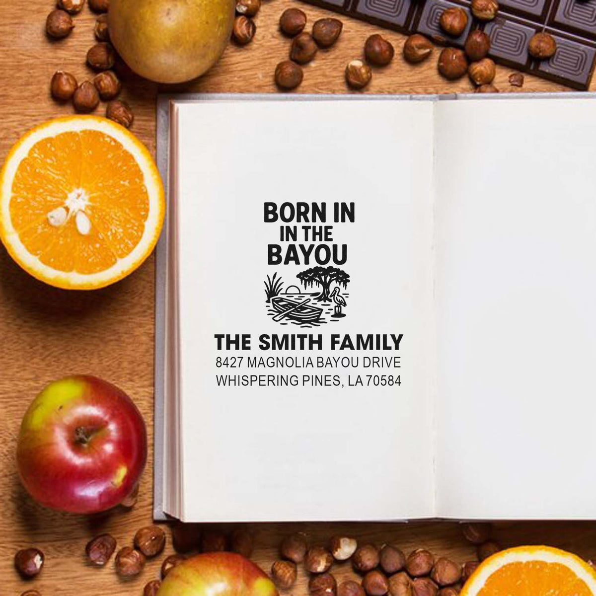 Custom Born in the Bayou family address rubber stamp with Louisiana return address on an open notebook.