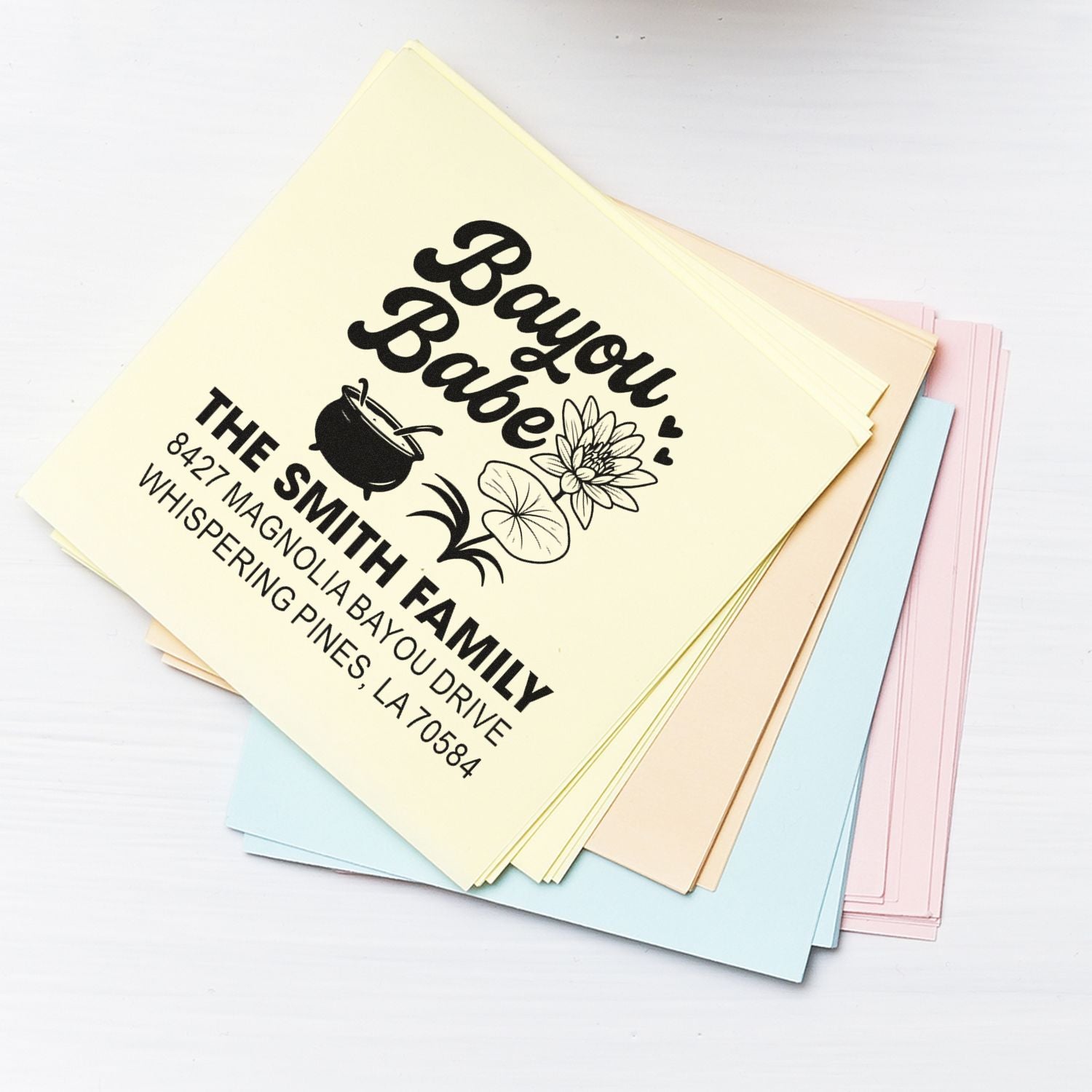 Custom rubber address stamp on pastel cards, featuring Bayou Babe family name, floral design, and return address for mailing.