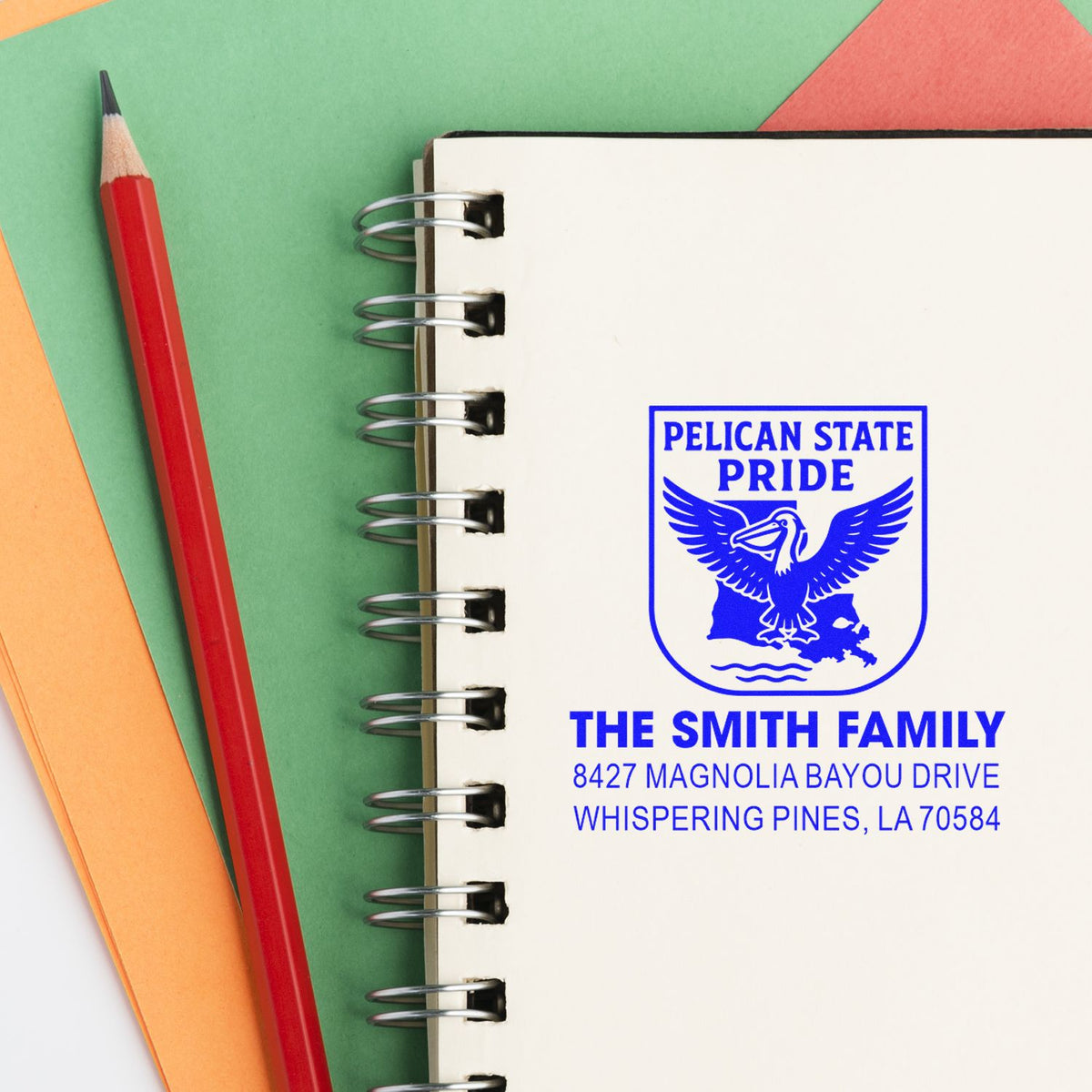 Custom rubber stamp with Pelican State Pride logo and return address for The Smith Family on a spiral notebook.