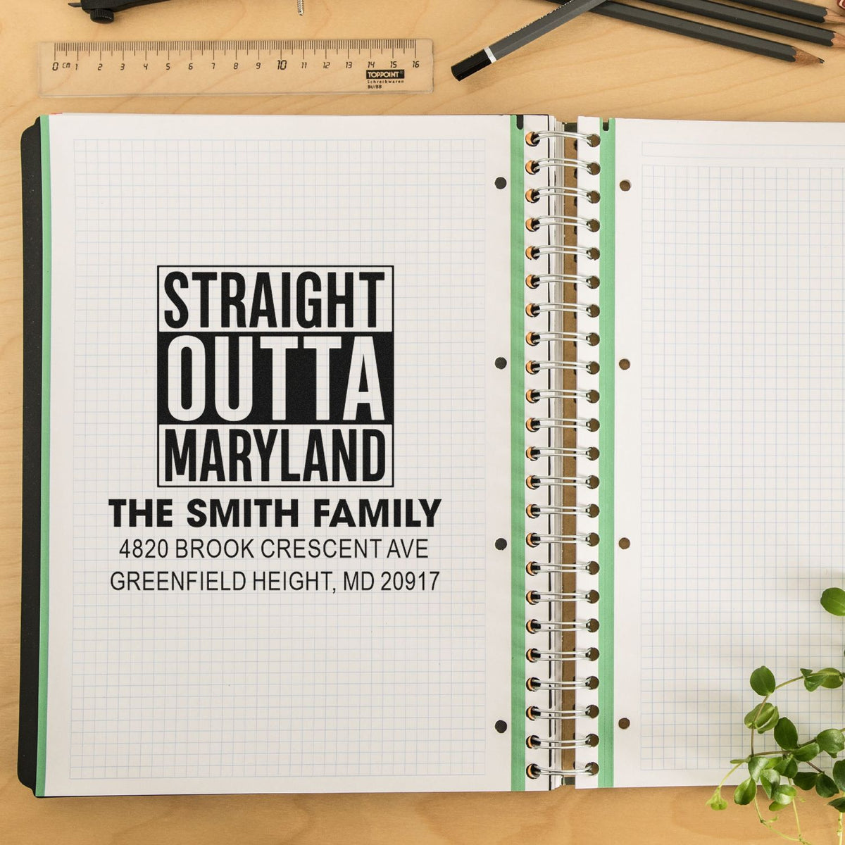 Custom rubber stamp impression on notebook page with Straight Outta Maryland and personalized family address.