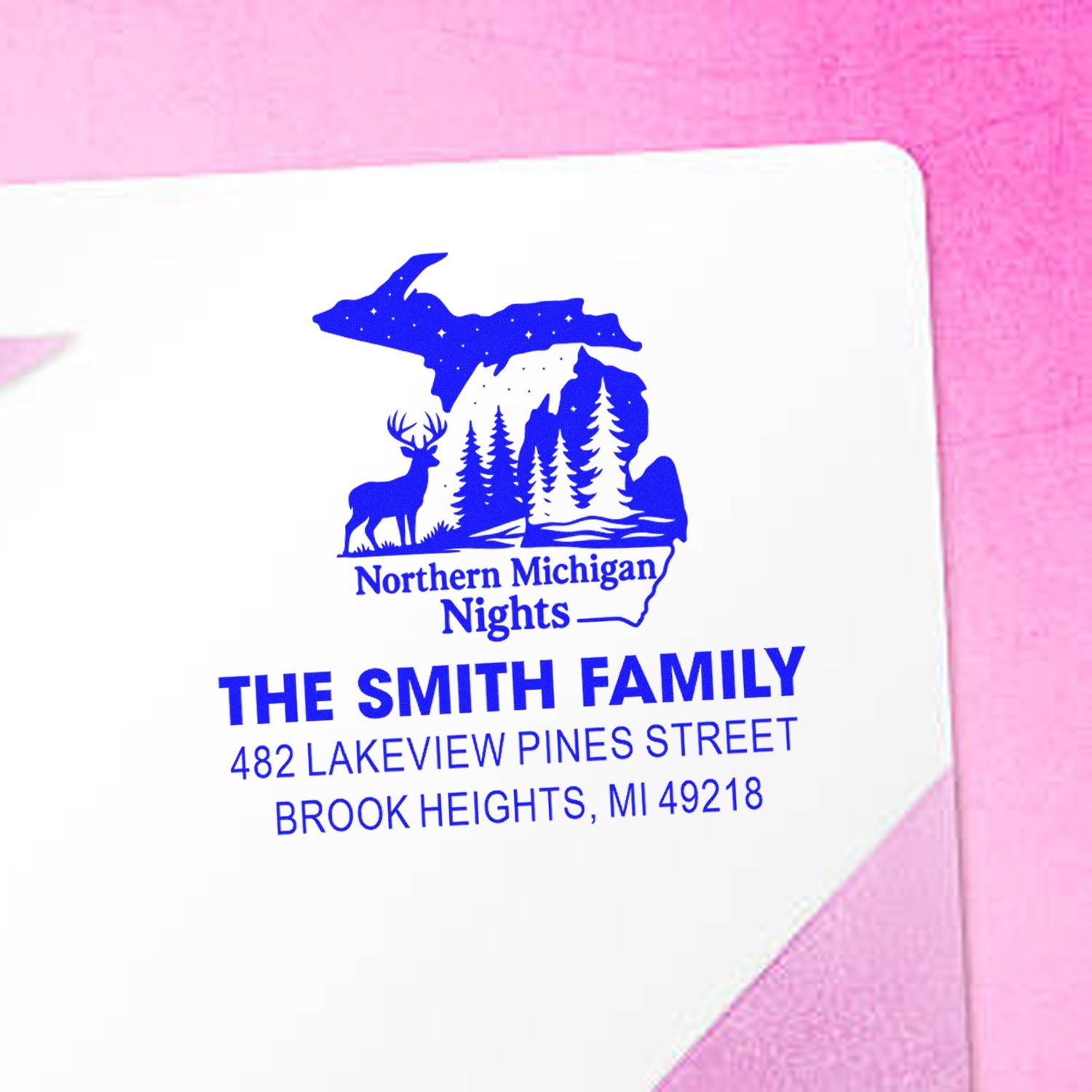 Custom family return address rubber stamp on envelope with Northern Michigan Nights map, deer, and forest design.