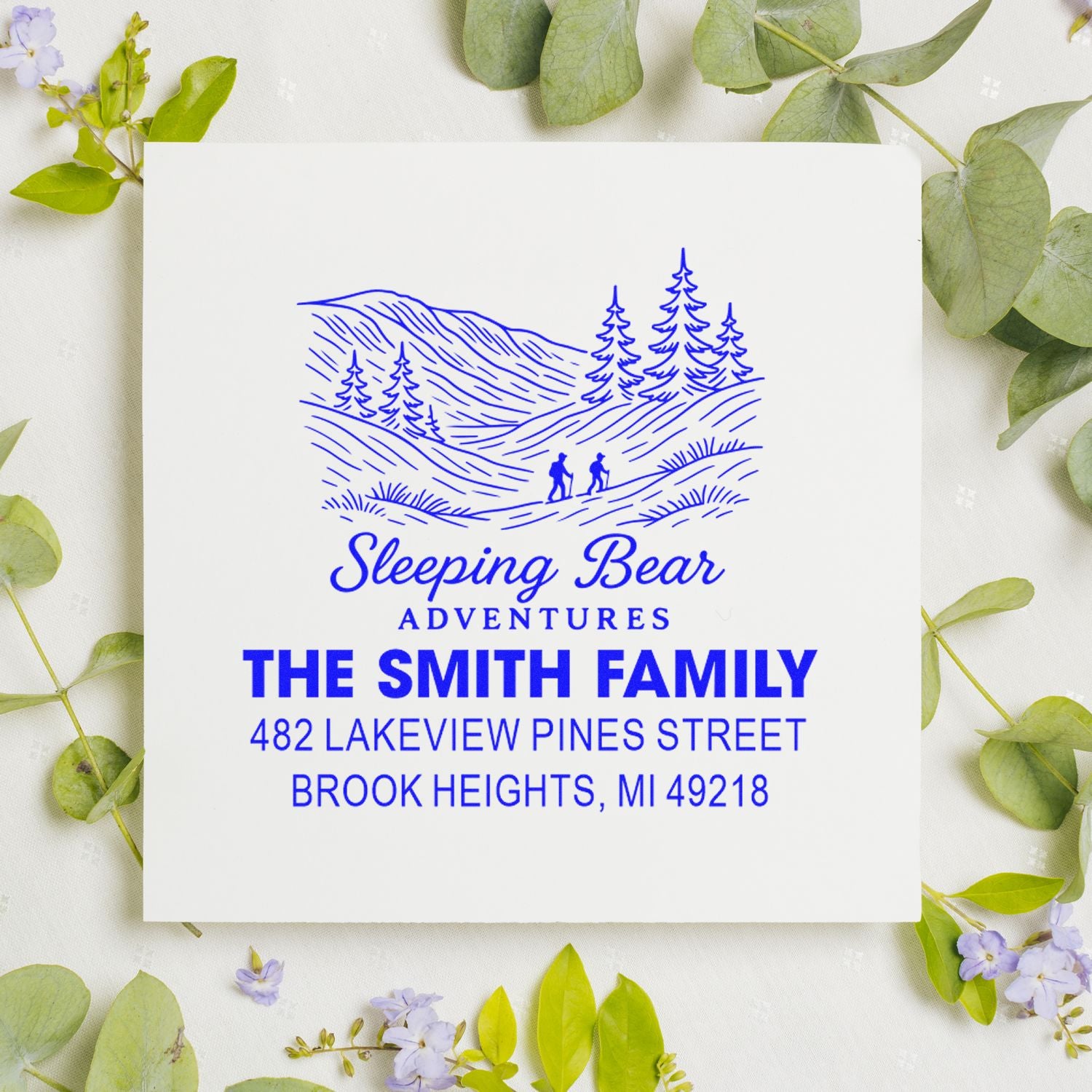 Custom rubber return address stamp for Sleeping Bear Adventures, featuring a mountain hiker logo and The Smith Family address.