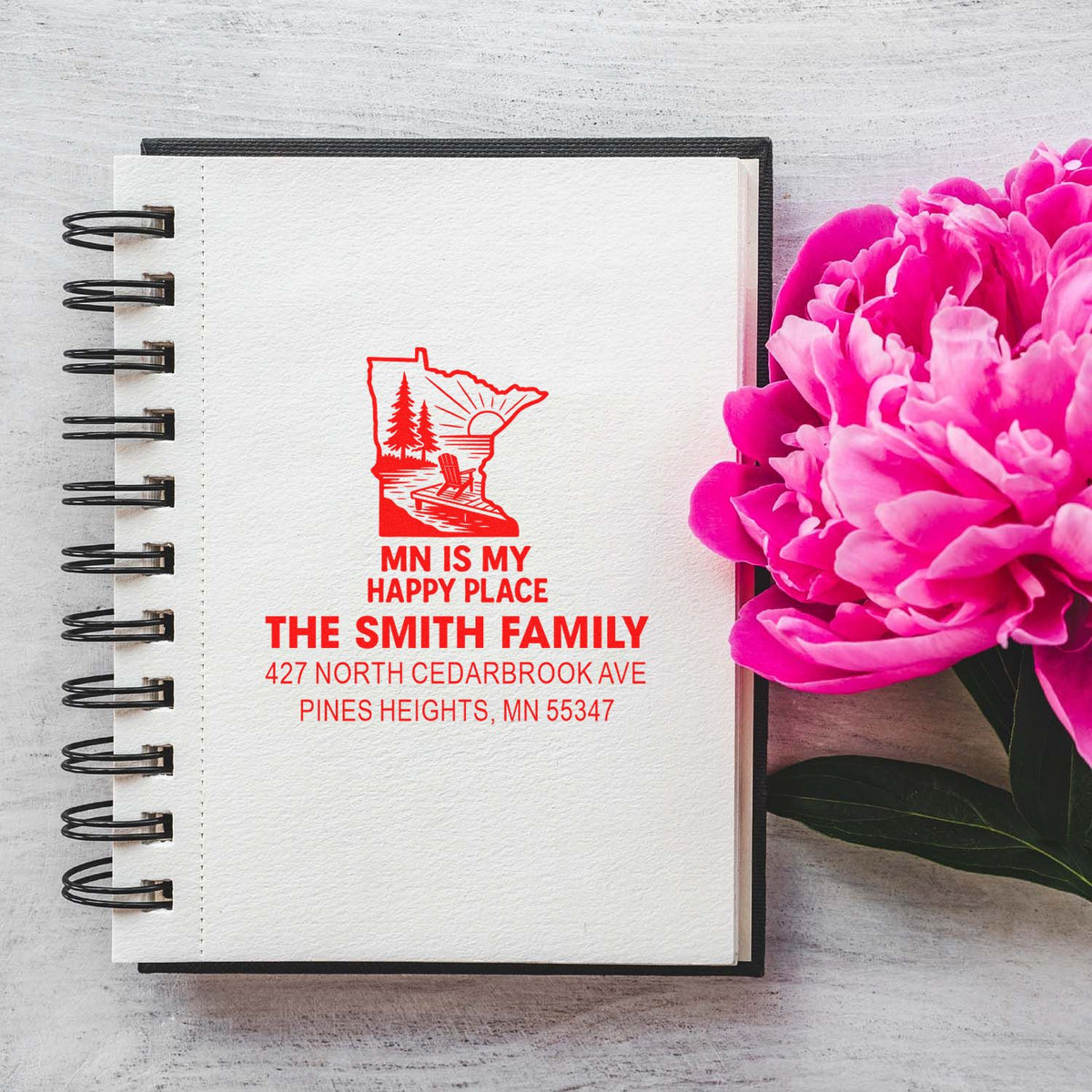 Personalized Minnesota family address rubber stamp on notebook, featuring state outline and return address for stationery.