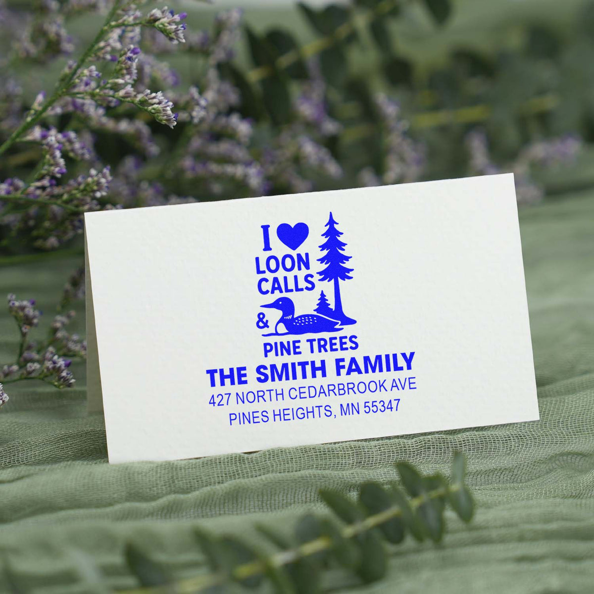 Custom rubber stamp with loon, pine tree, and family name design for rustic Minnesota address labeling and stationery.