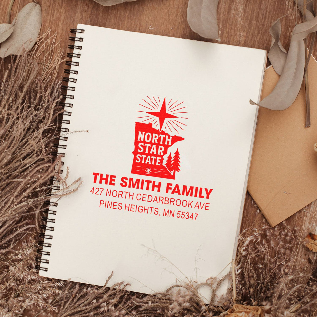 Custom return address rubber stamp with North Star State design, showing The Smith Family and Minnesota address on a notebook.