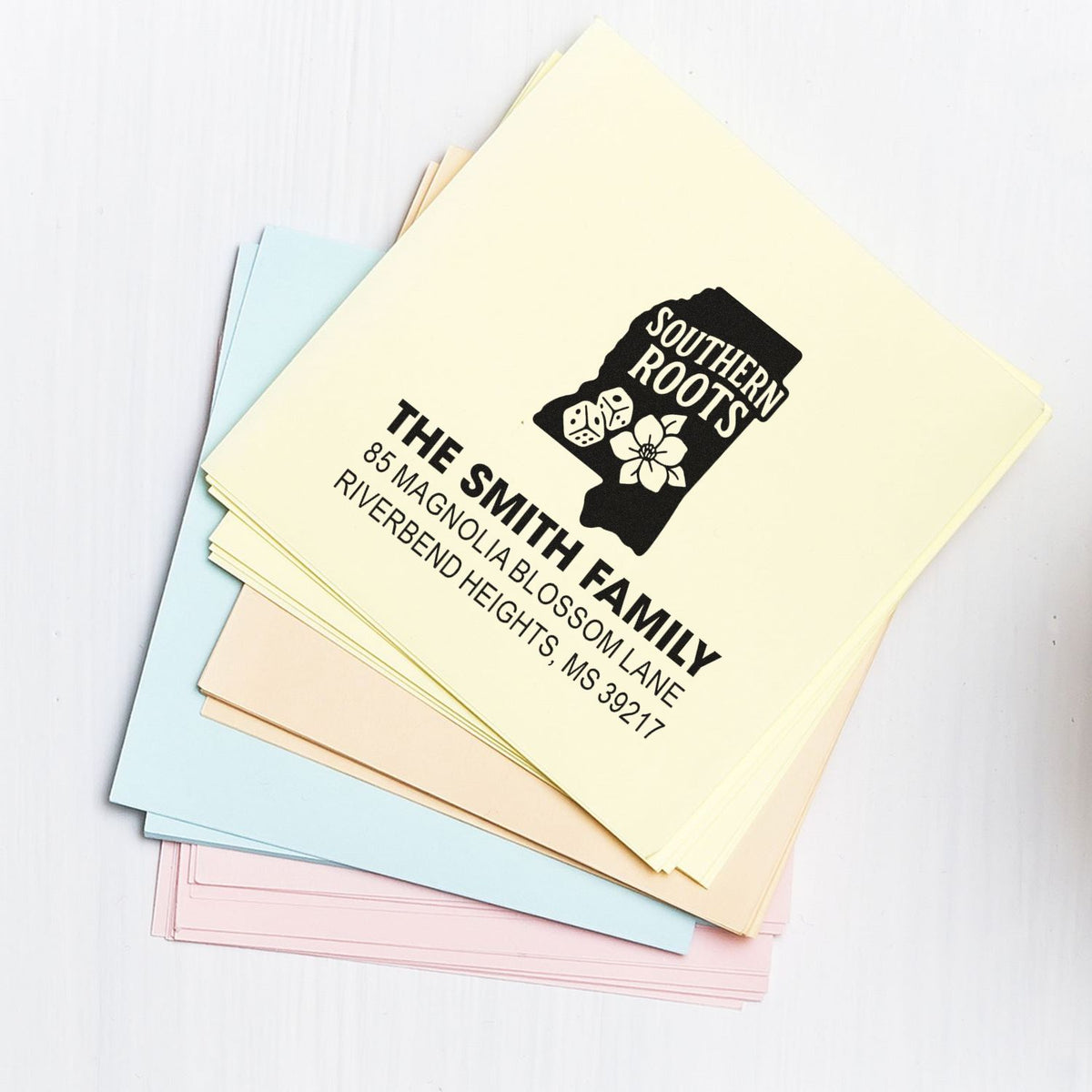 Custom return address rubber stamp on pastel envelopes, featuring The Smith Family Southern Roots design for personalized mail.