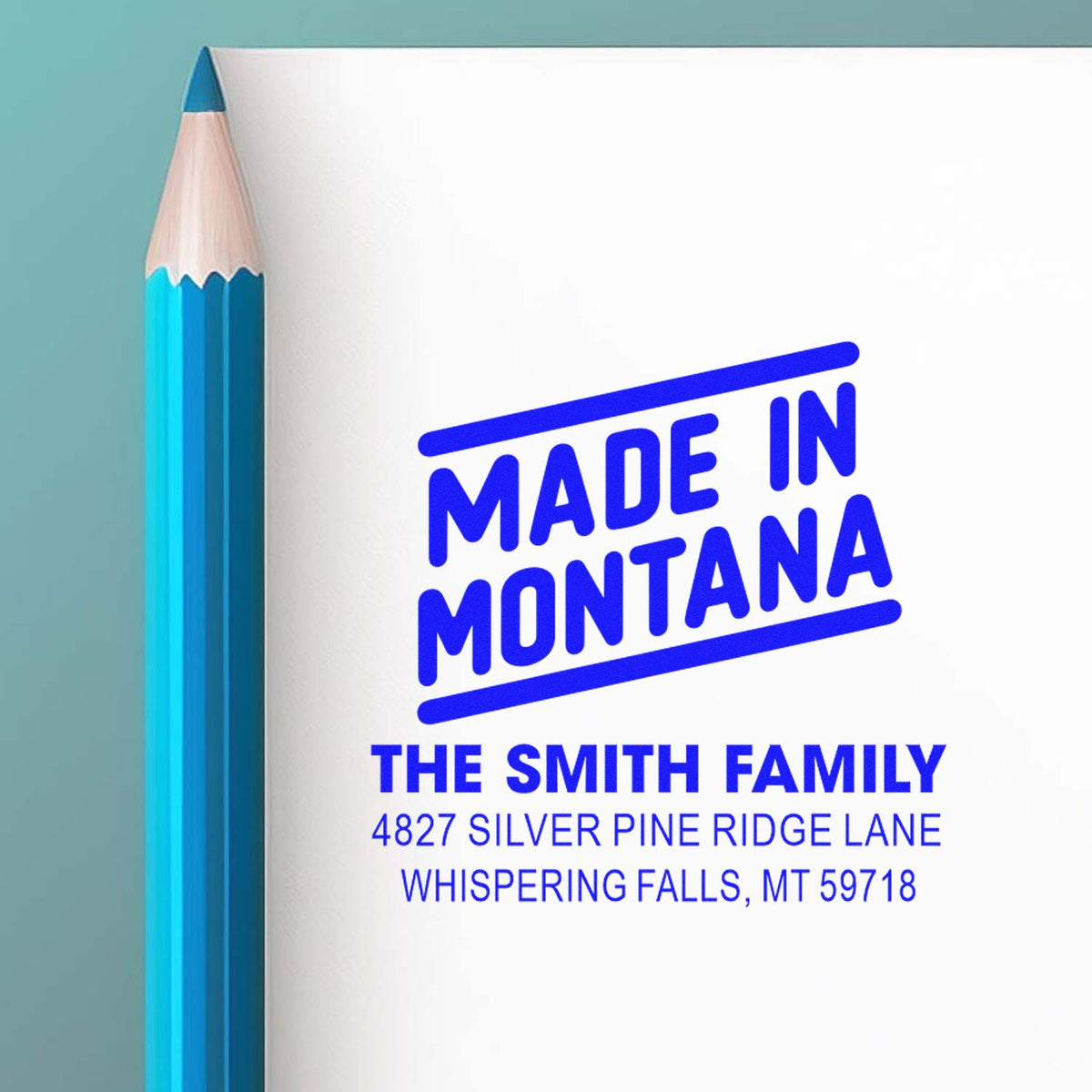 Custom Made in Montana rubber stamp with family name and address imprint beside a blue pencil.