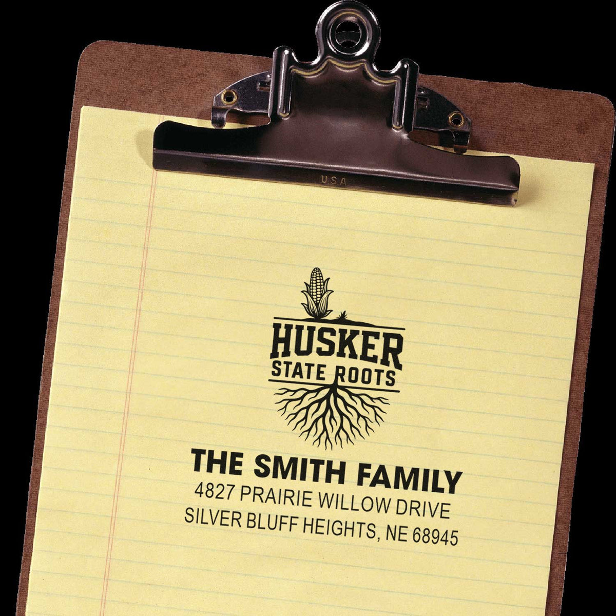 Custom rubber address stamp impression with Husker State Roots logo and The Smith Family return address on clipboard paper.