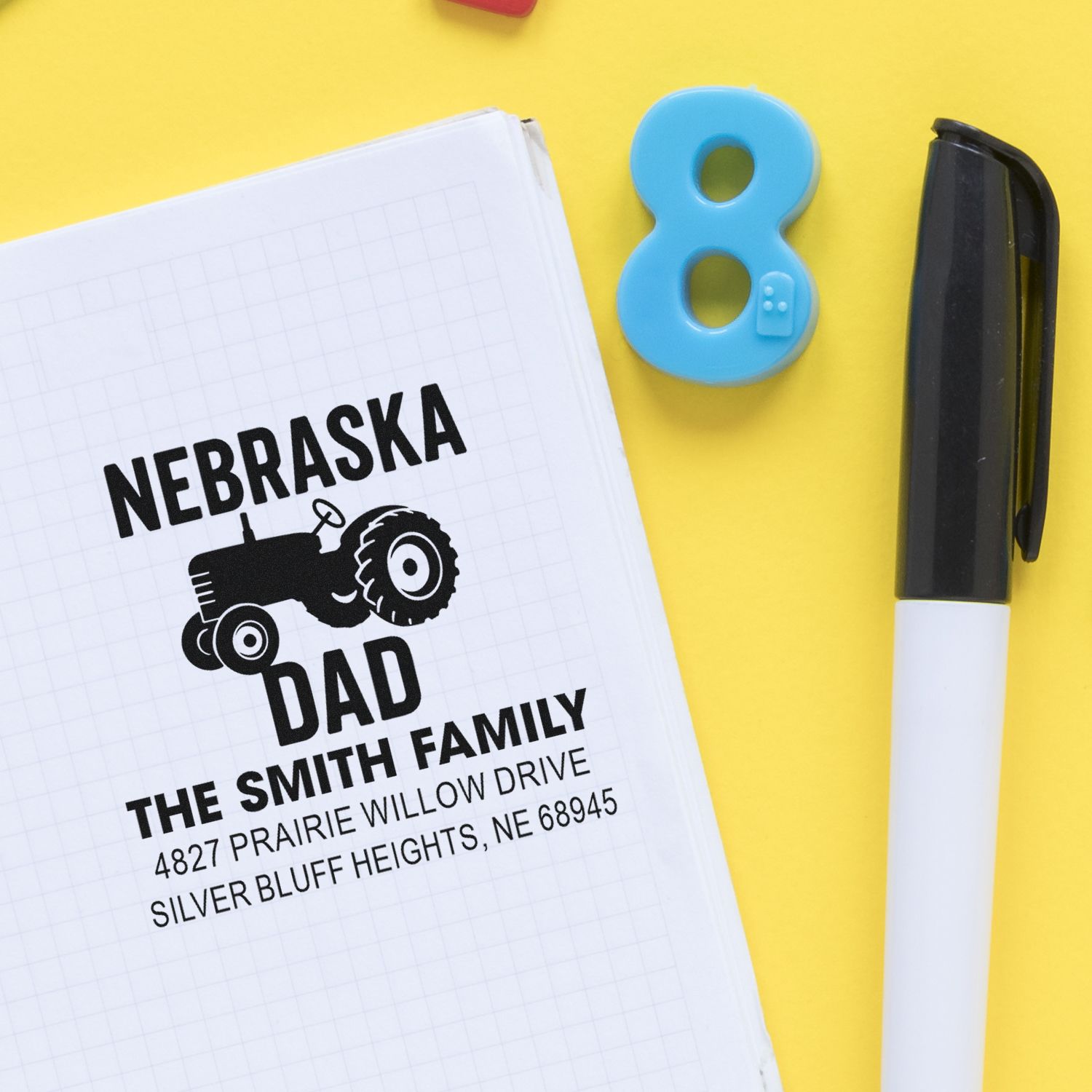 Personalized Nebraska tractor address rubber stamp with family name and address printed on notebook.