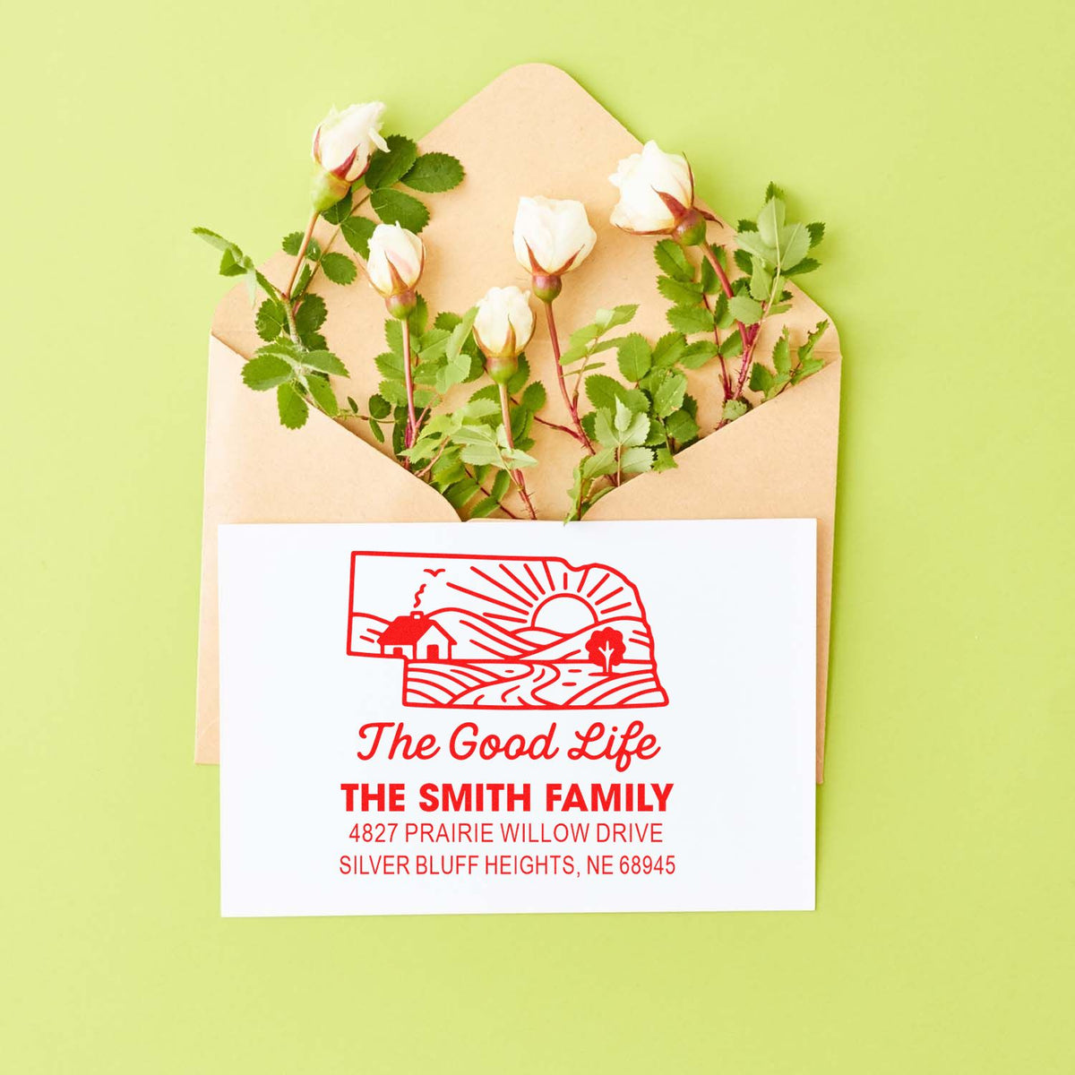 Personalized family return address rubber stamp with farmhouse design displayed on an envelope with flowers.