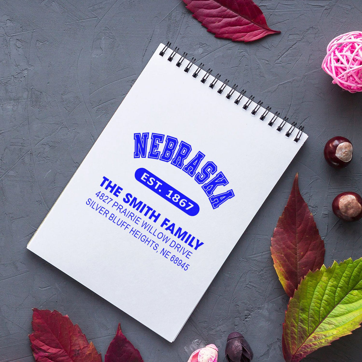 Custom rubber address stamp on notebook featuring Nebraska return address, The Smith Family, and Est. 1867 design.
