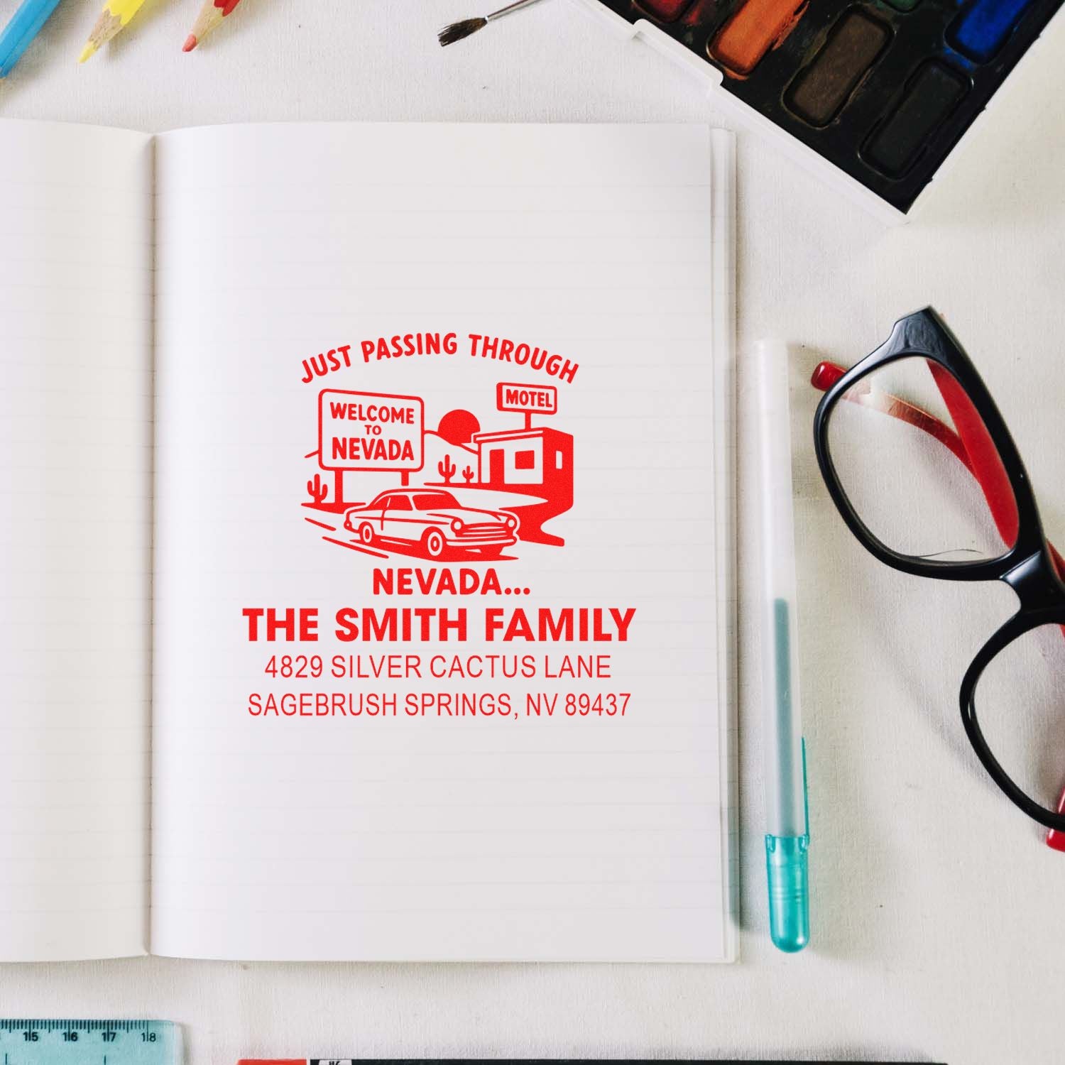 Custom rubber return address stamp with Nevada travel design, personalized family name, and address on notebook page.