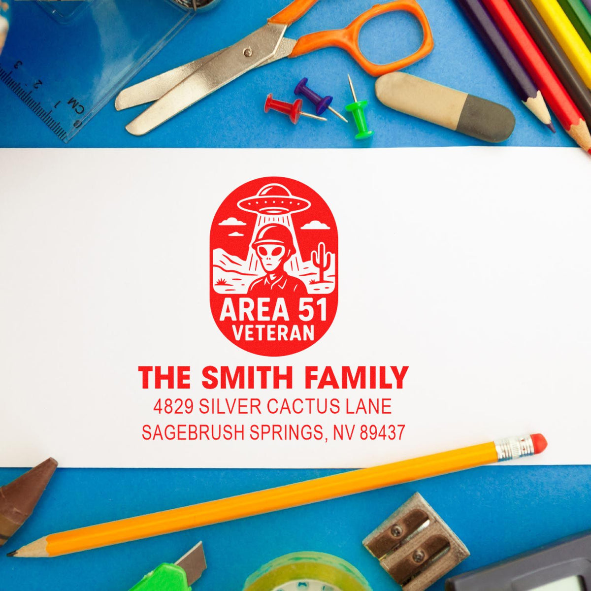 Personalized custom address stamp with Area 51 Veteran design and Smith family return address, shown with school supplies.