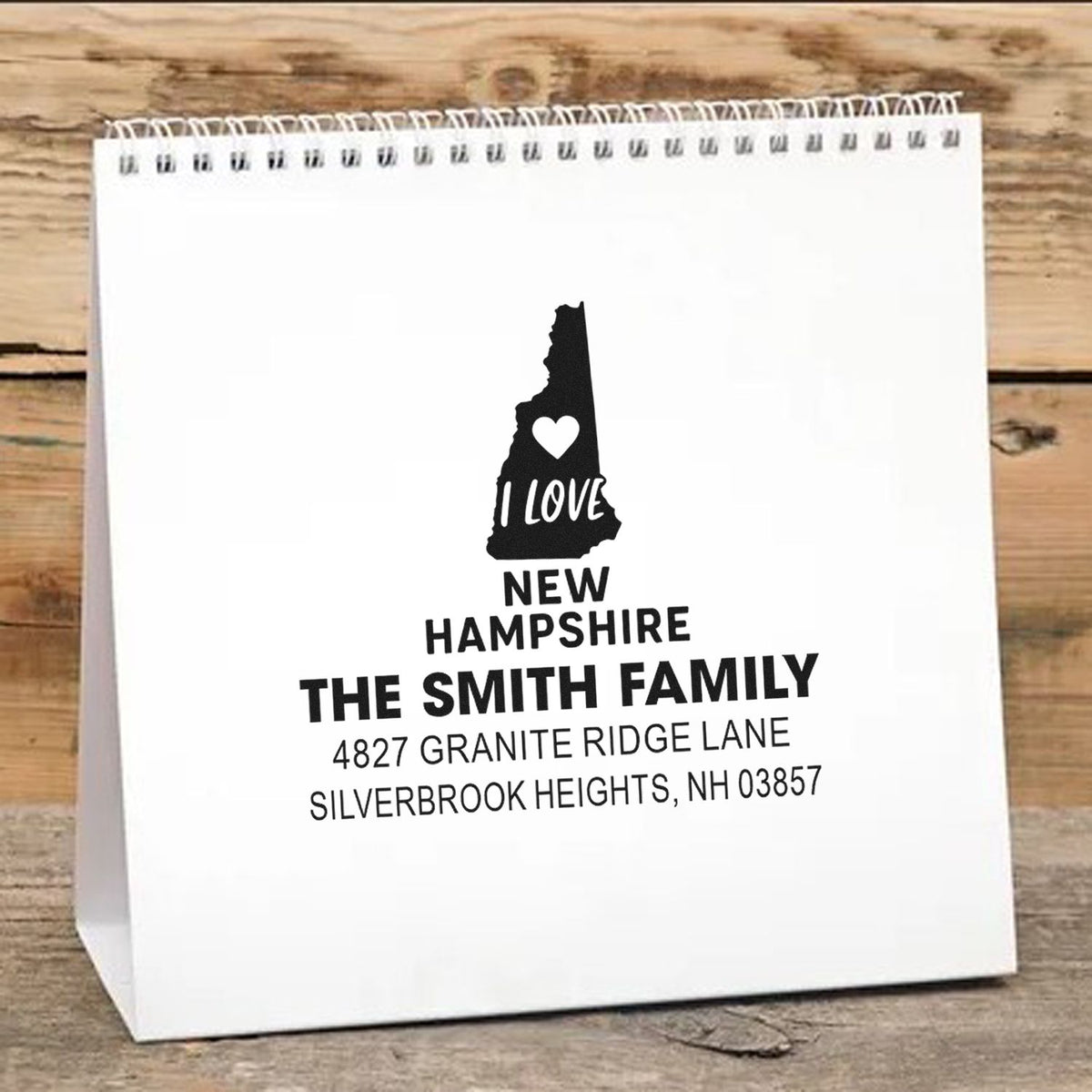 Custom New Hampshire family address rubber stamp on white gift bag, featuring state silhouette, family name, and return address.