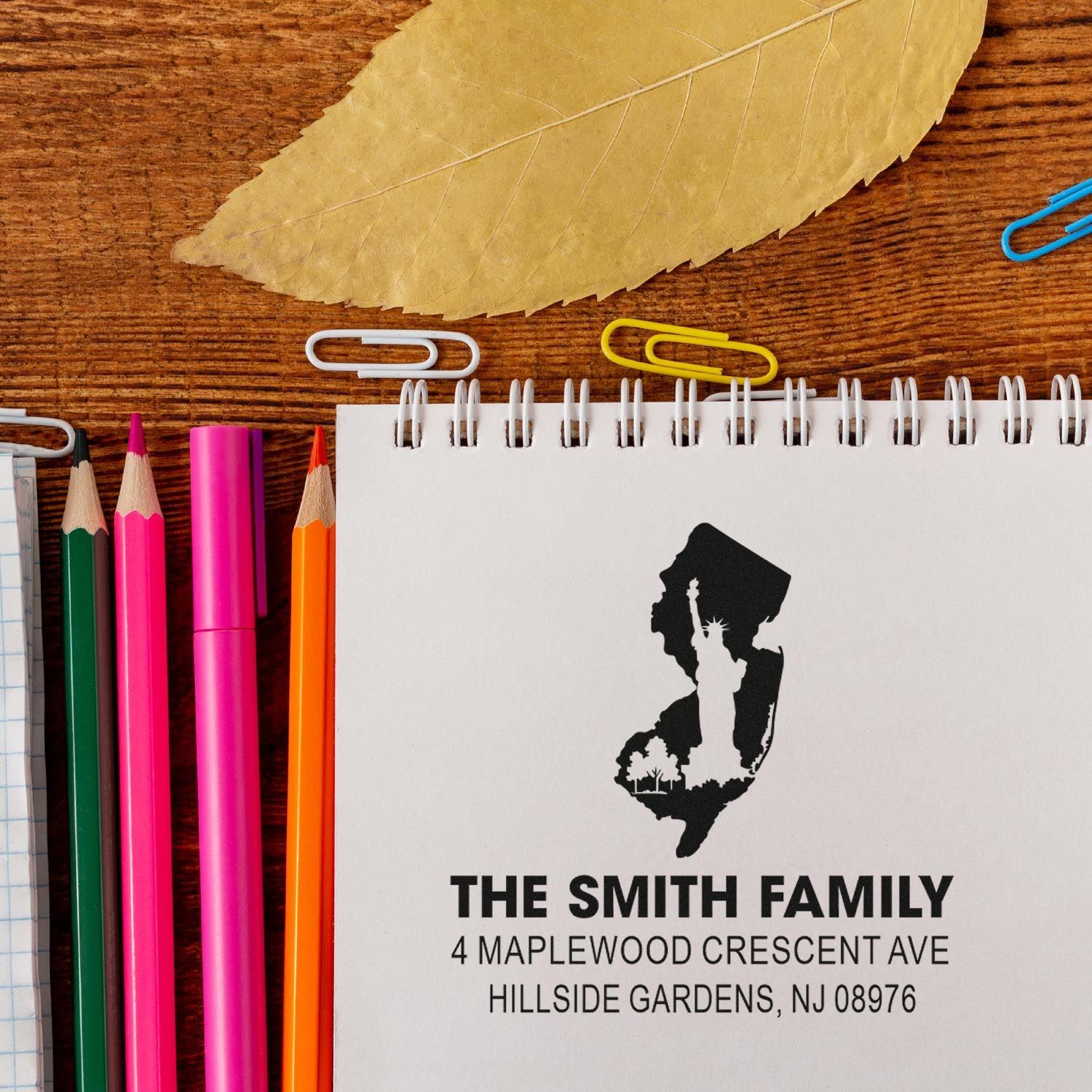 Custom rubber address stamp for The Smith Family return mailing address in New Jersey, shown on a notebook with stationery.
