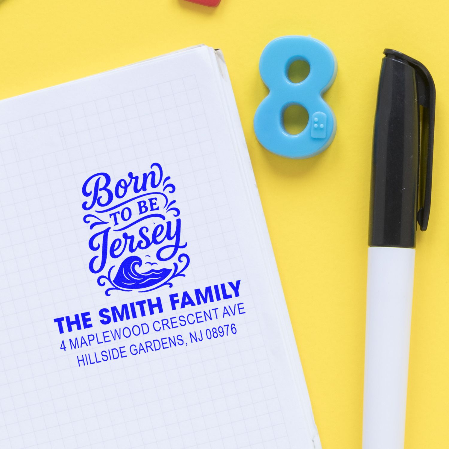 Custom rubber address stamp with Born to Be Jersey design on notebook, showing personalized family mailing stamp.