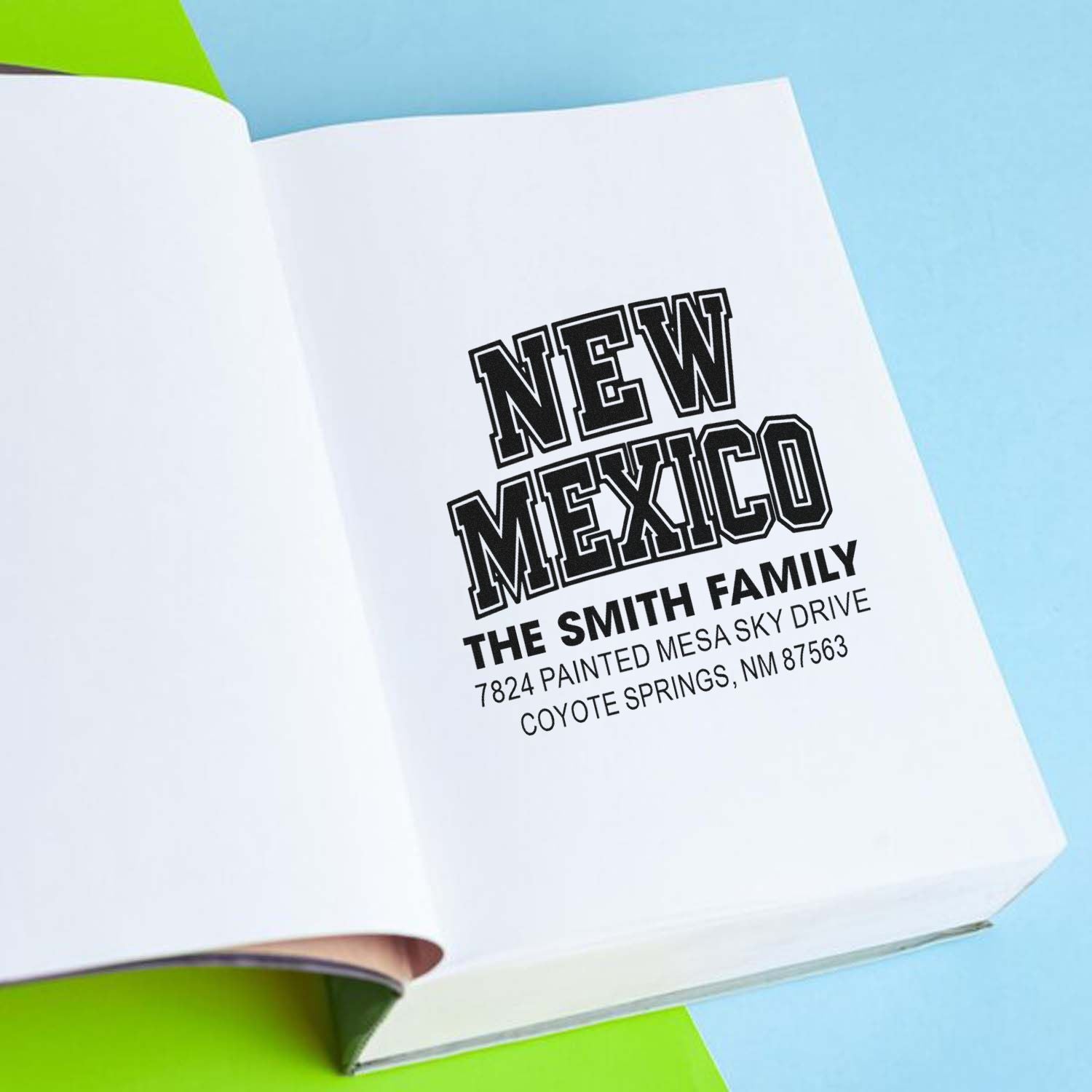 Custom rubber address stamp on open notebook, featuring New Mexico, The Smith Family, and return address details.