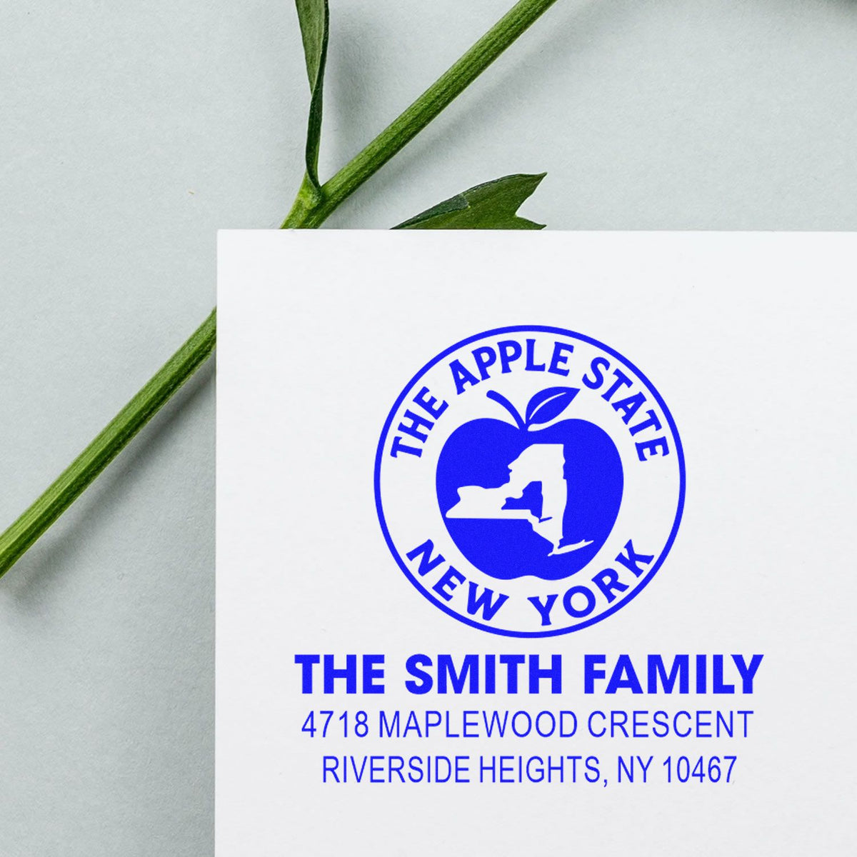 Personalized return address rubber stamp featuring The Smith Family, New York state apple logo, and blue address imprint.