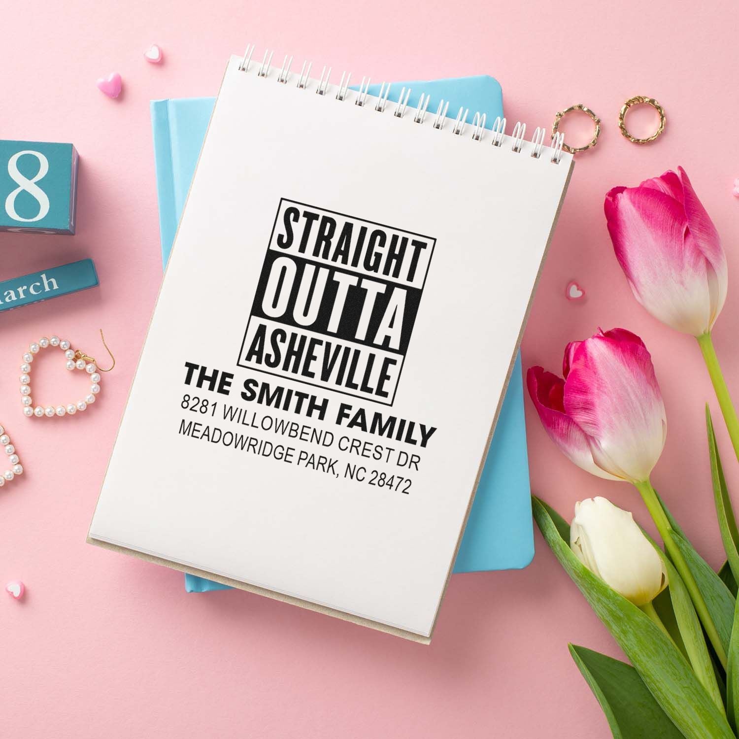 Custom rubber address stamp with Straight Outta Asheville family design and personalized mailing address imprint on notebook.