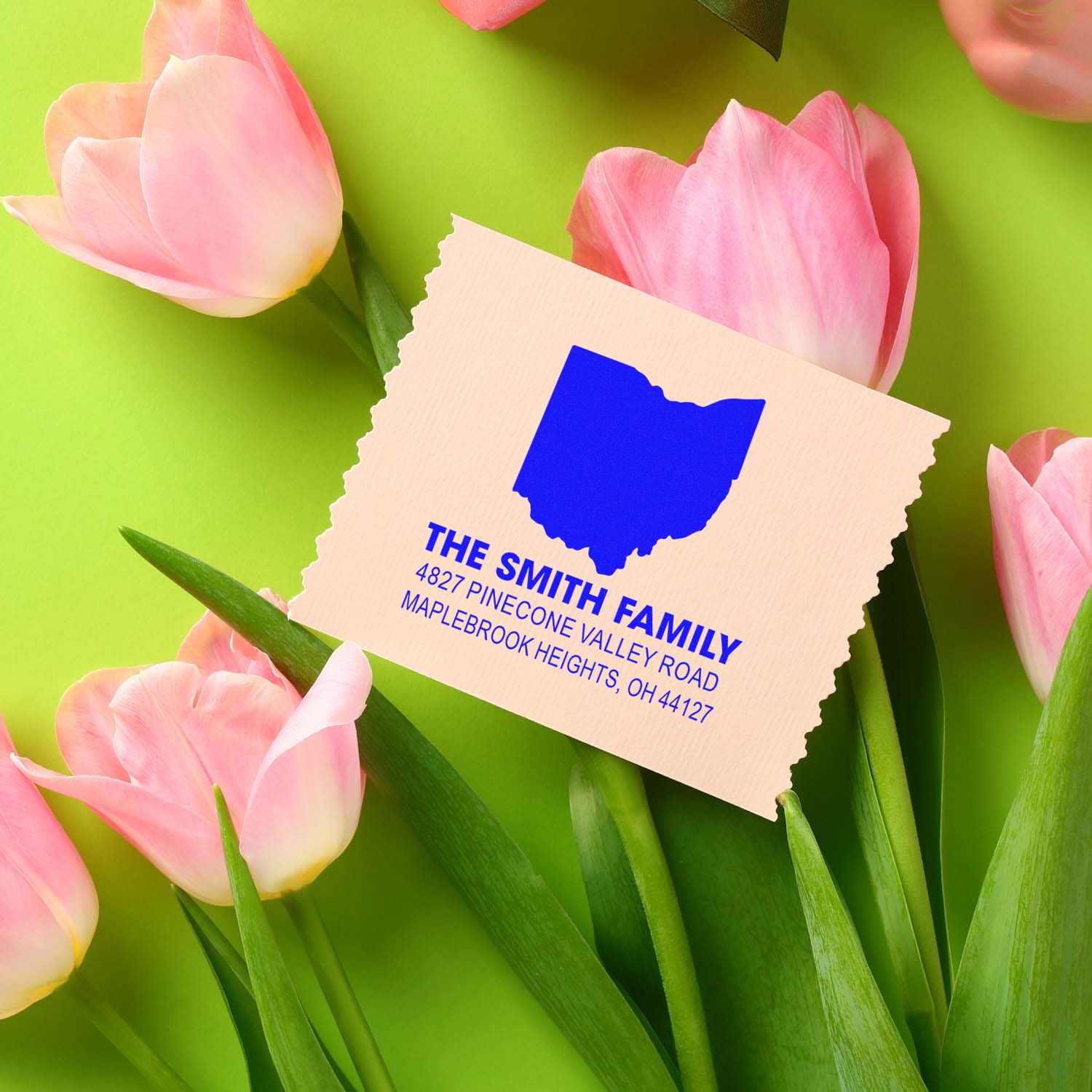 Personalized return address rubber stamp for The Smith Family, shown on spring tulips with a bright green background.