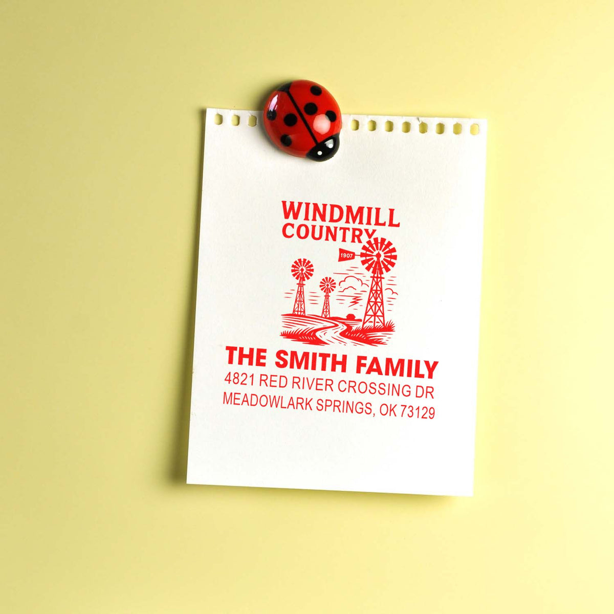 Custom return address rubber stamp impression with windmill design, The Smith Family name, and mailing address on paper.