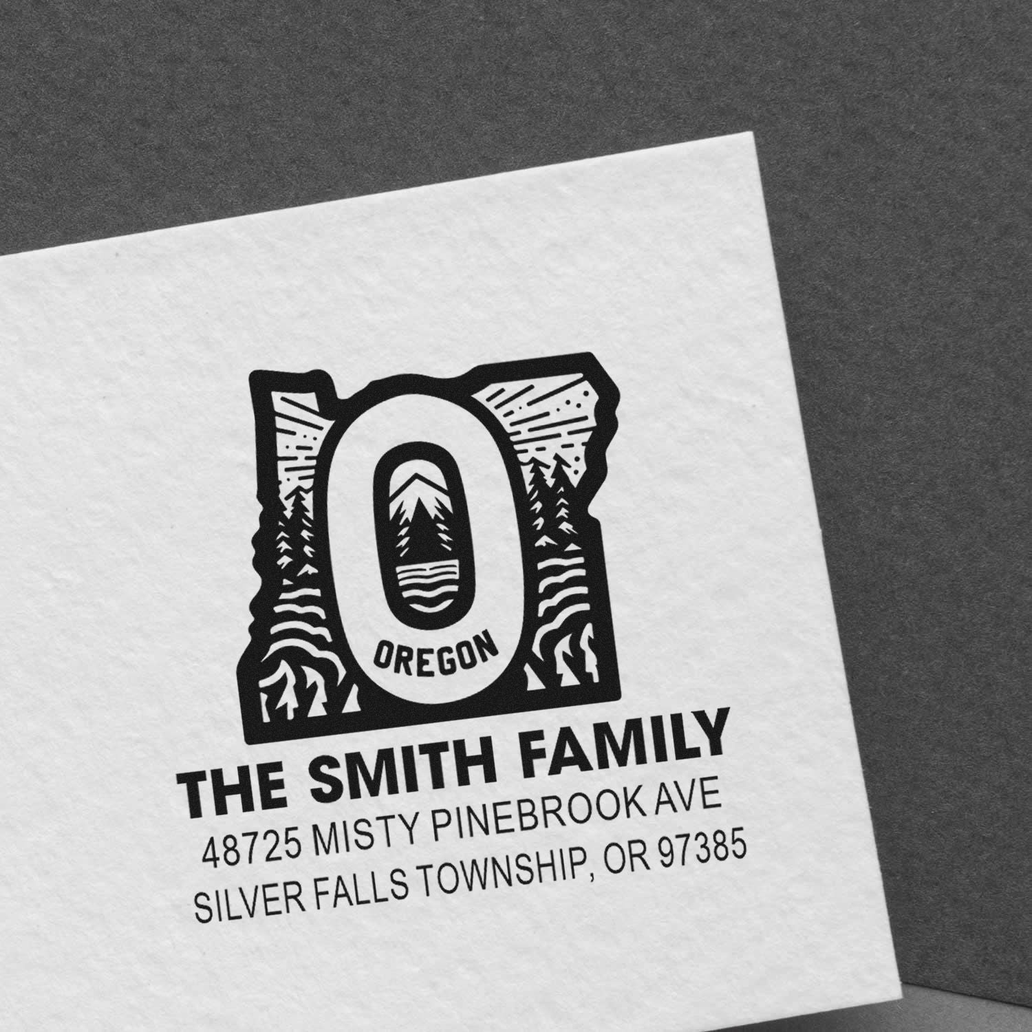 Custom Oregon family return address rubber stamp with pine tree design on paper.