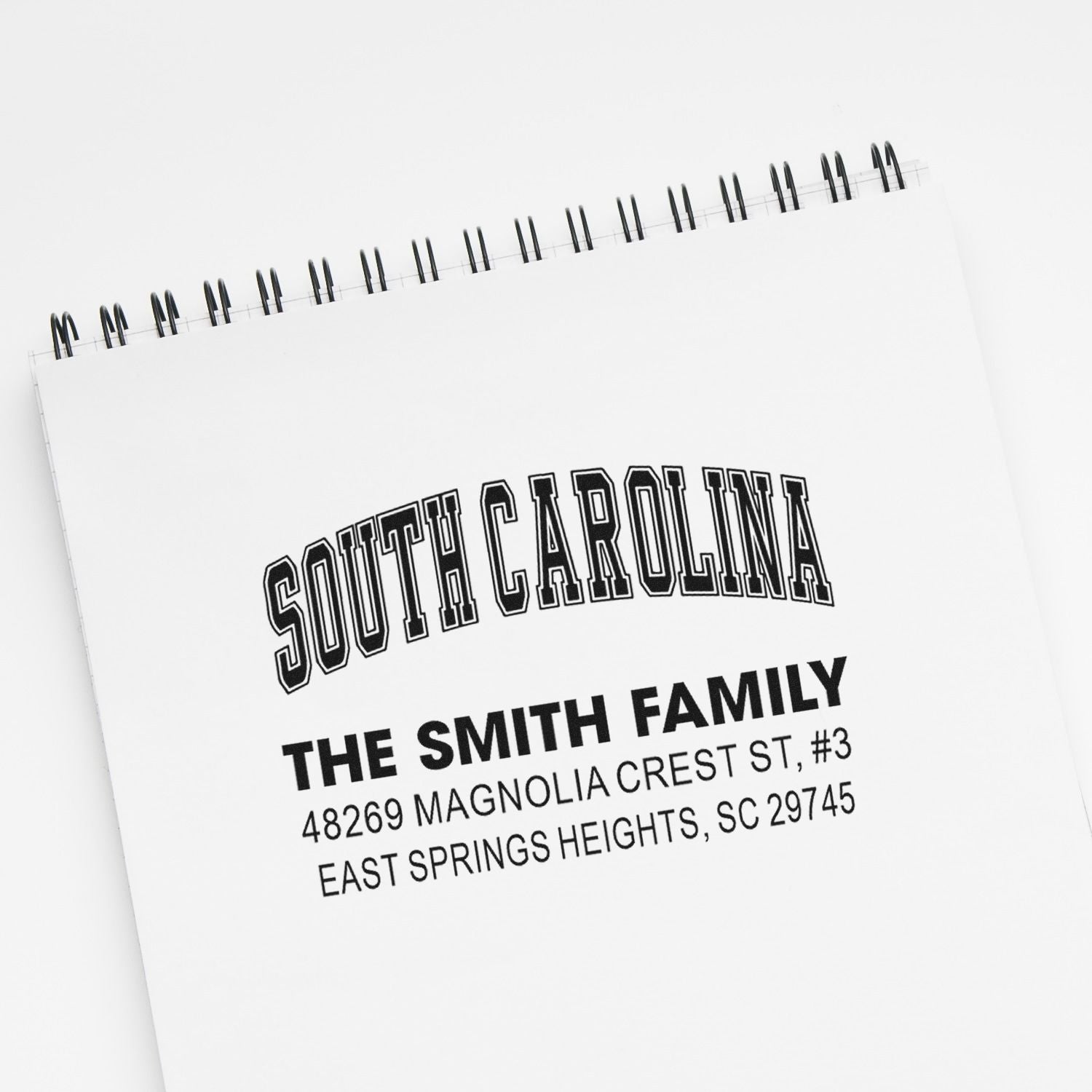 Custom South Carolina family address rubber stamp on notebook, featuring The Smith Family and mailing address.