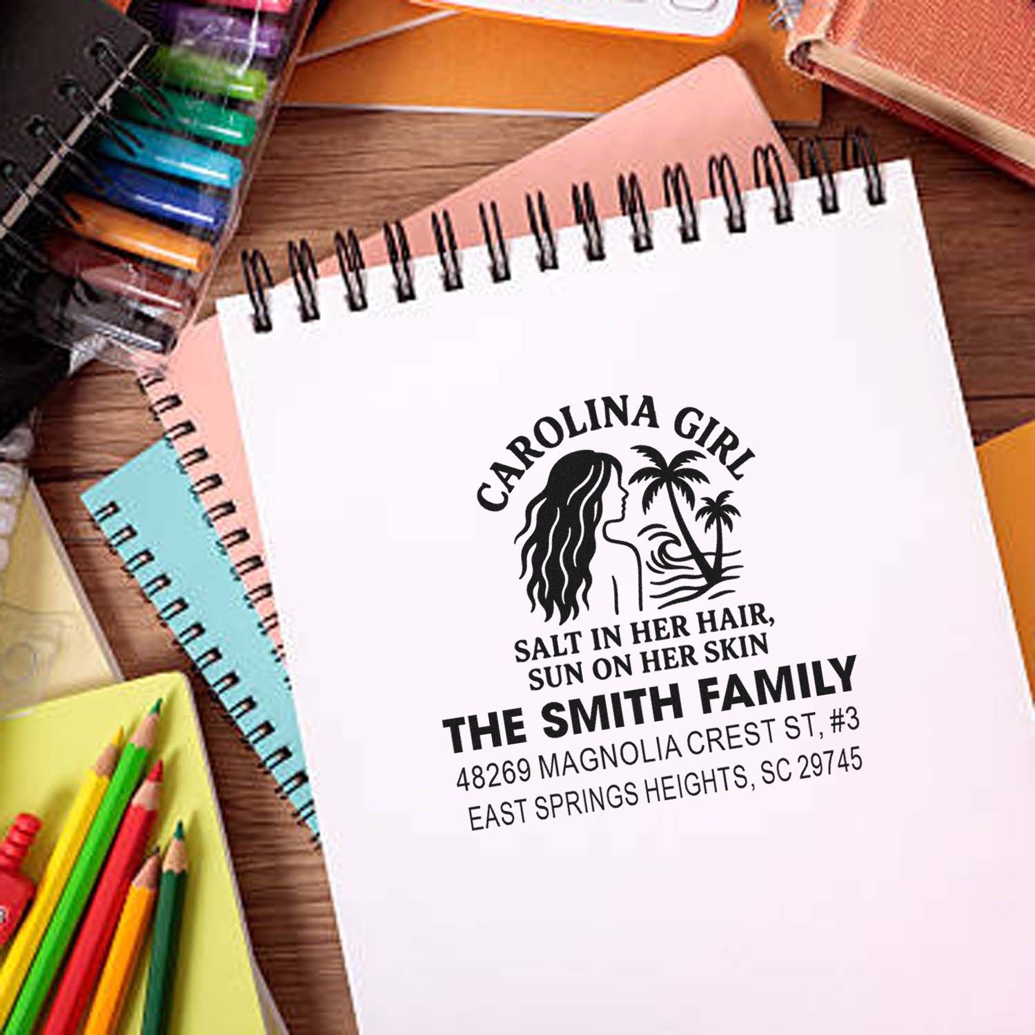 Personalized Carolina Girl rubber stamp with family name and address on a notebook, ideal for custom return address stamping.