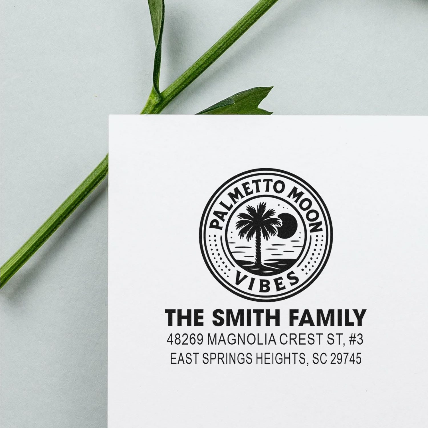 Custom address rubber stamp for The Smith Family with Palmetto Moon Vibes logo on white paper