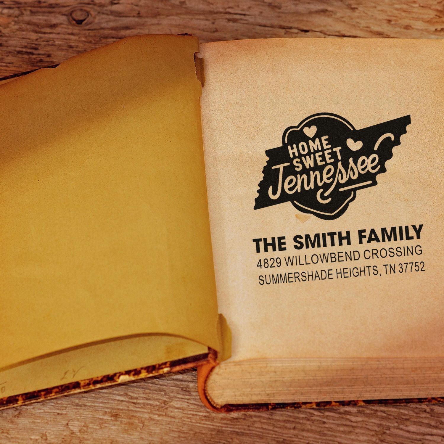 Custom rubber stamp imprint with Home Sweet Tennessee design and family address on an open book page.