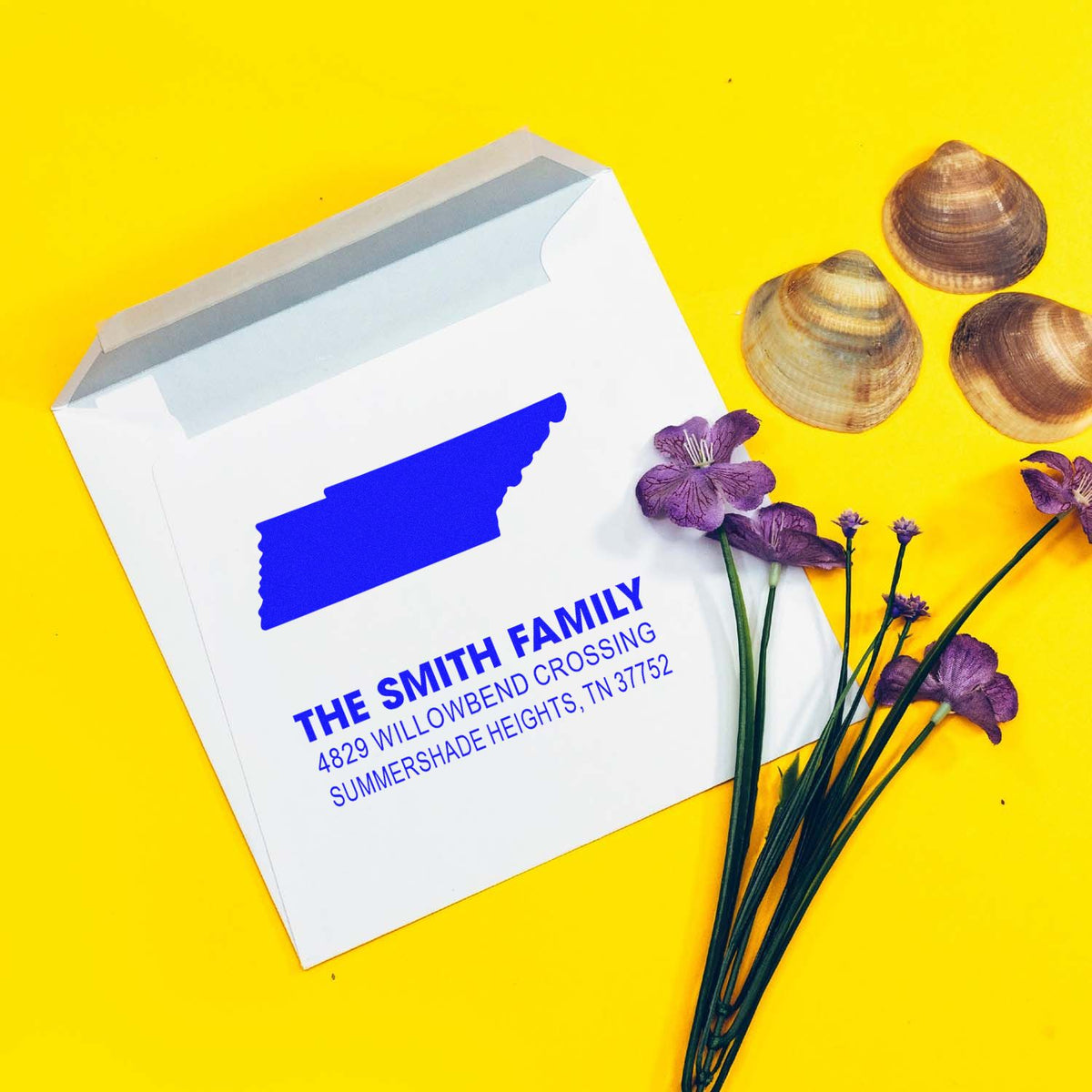 Personalized return address rubber stamp on white envelope for The Smith Family, styled on a bright yellow background.