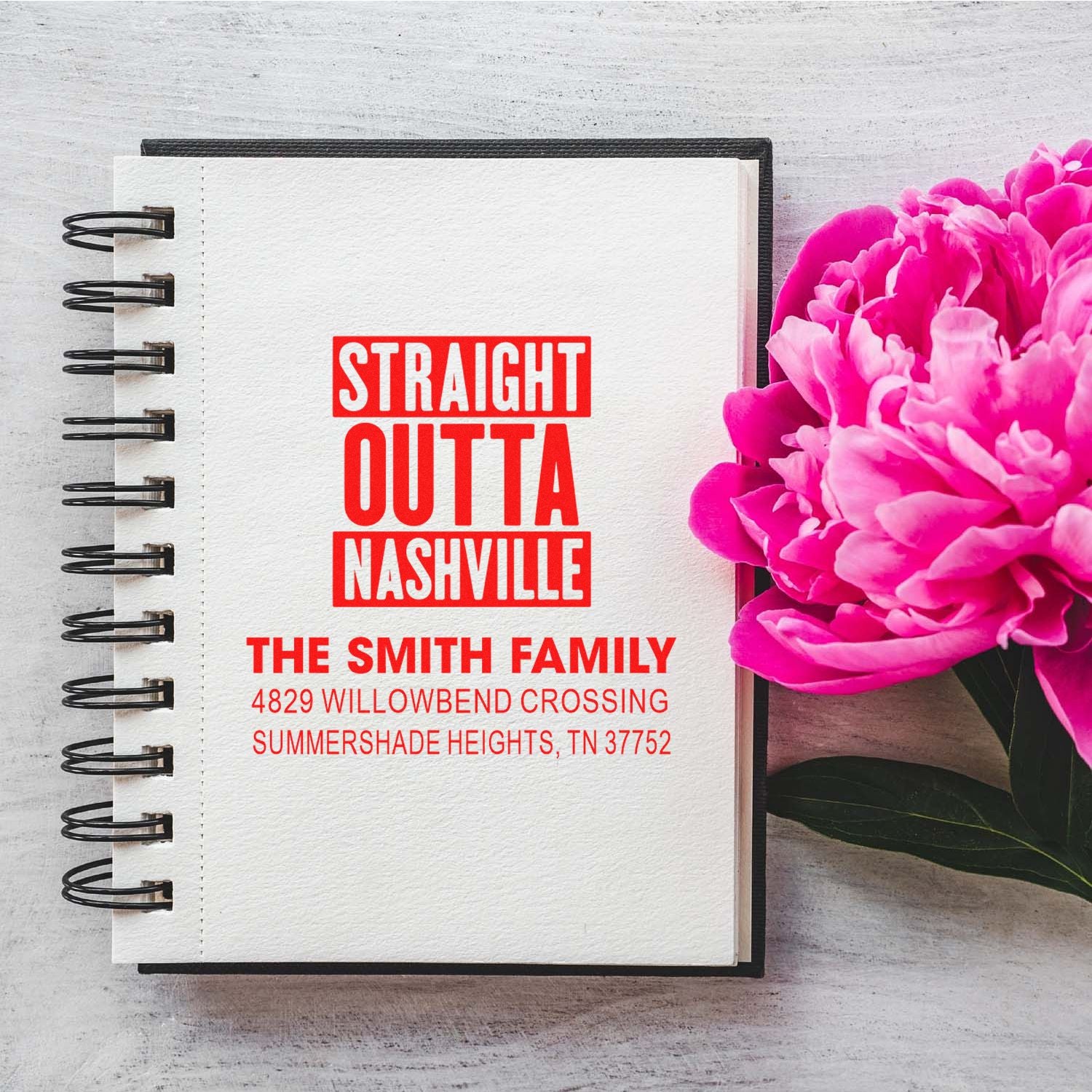 Custom return address rubber stamp on notebook, with Straight Outta Nashville family name and address design.