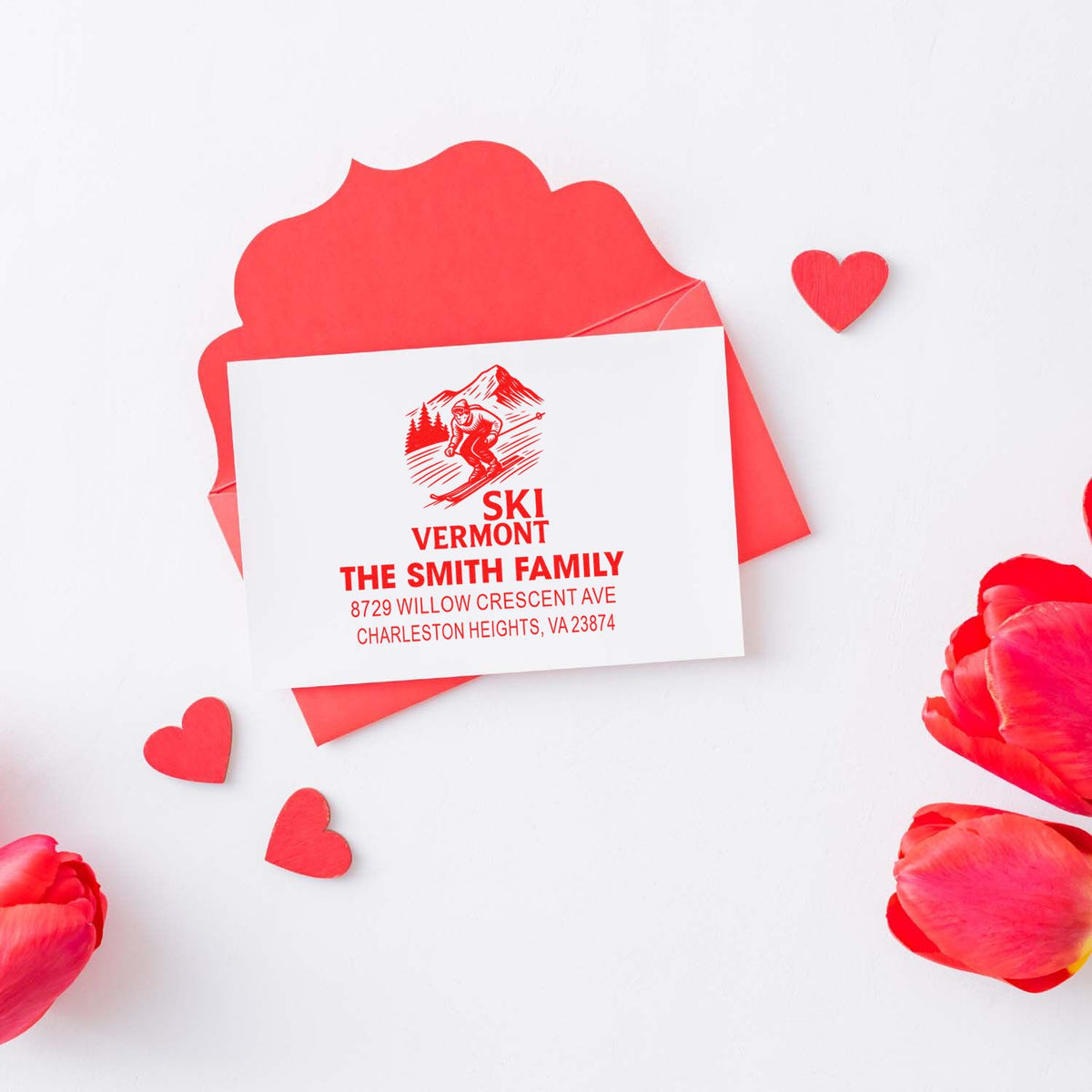 Custom red ski address stamp on Valentine stationery with envelope, hearts and flower petals, featuring The Smith Family return address.